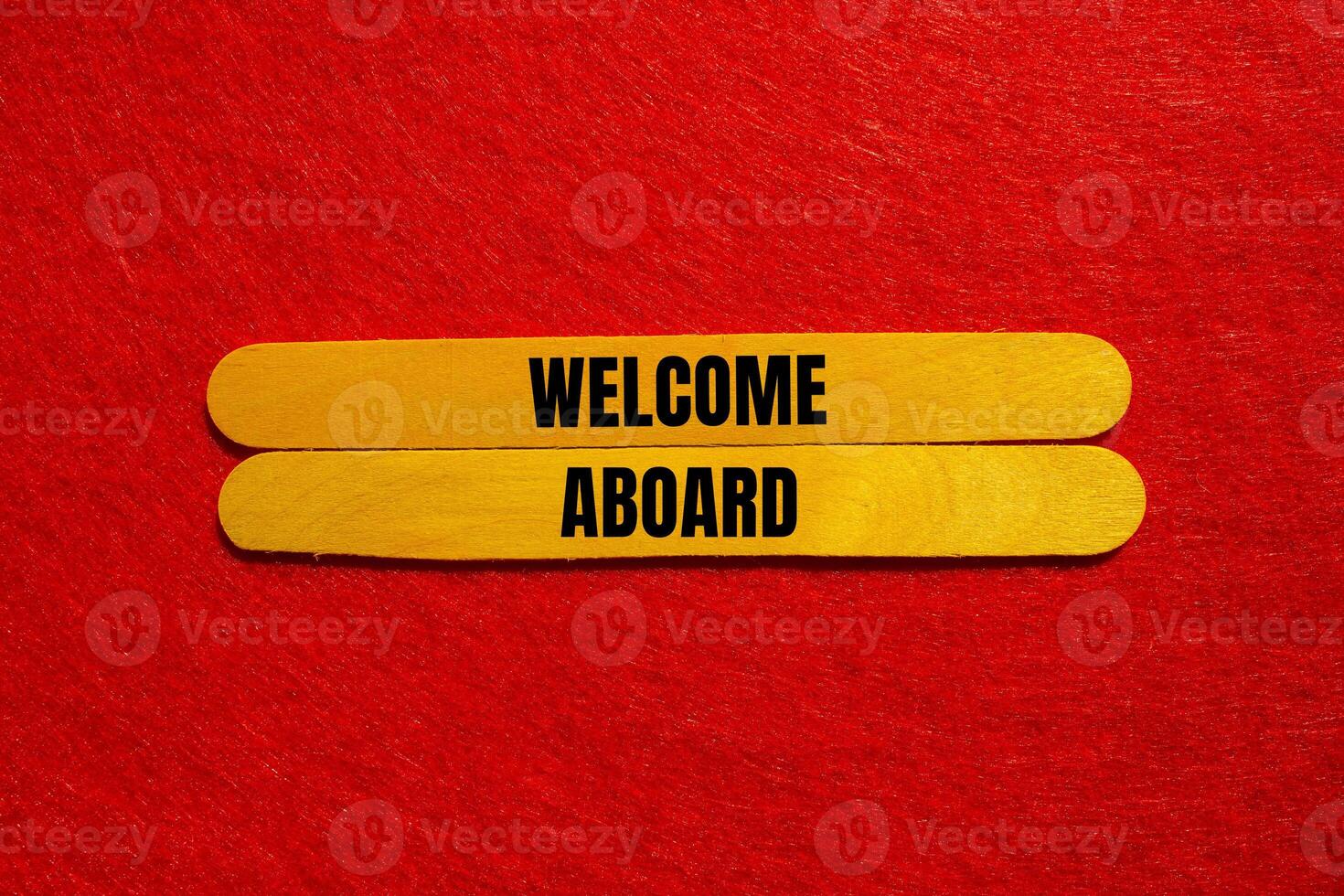 Welcome aboard message written on yellow wooden sticks with red background. Conceptual welcome aboard symbol. Copy space. photo