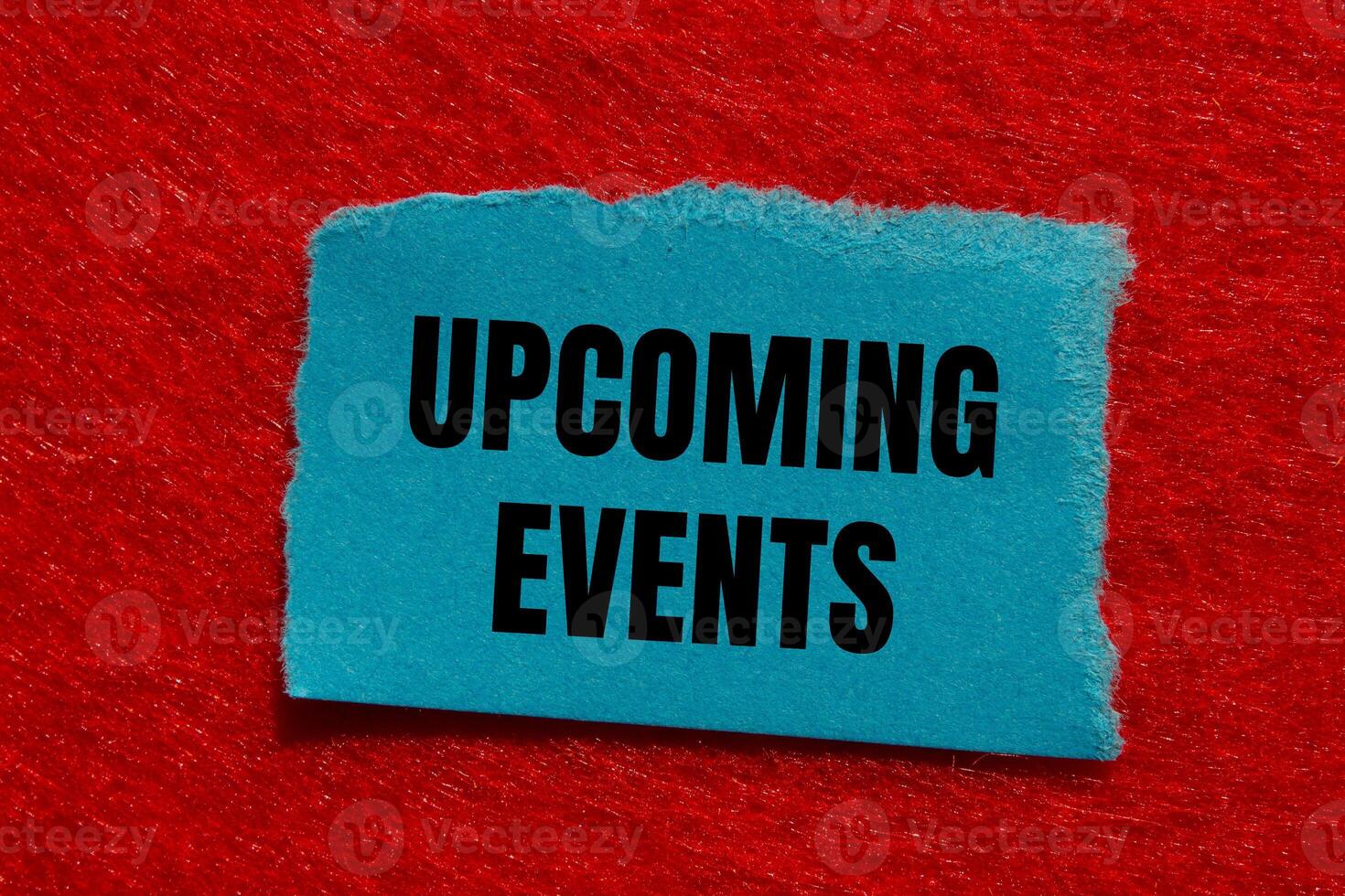Upcoming events message written on ripped torn blue paper piece with red background. Conceptual upcoming events symbol. Copy space. photo