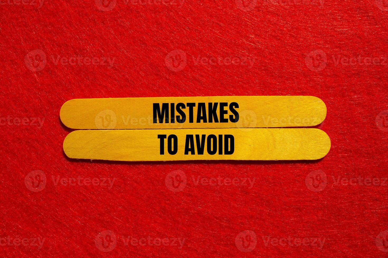 Mistakes to avoid message written on yellow wooden sticks with red background. Conceptual mistakes to avoid symbol. Copy space. photo