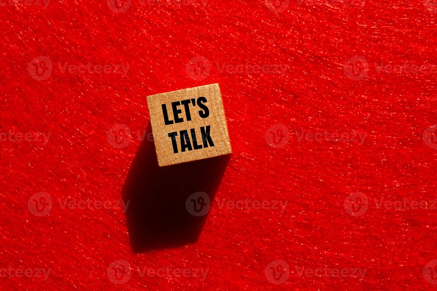 Let's talk message written on wooden cube with red background. Conceptual let's talk symbol. Copy space. photo