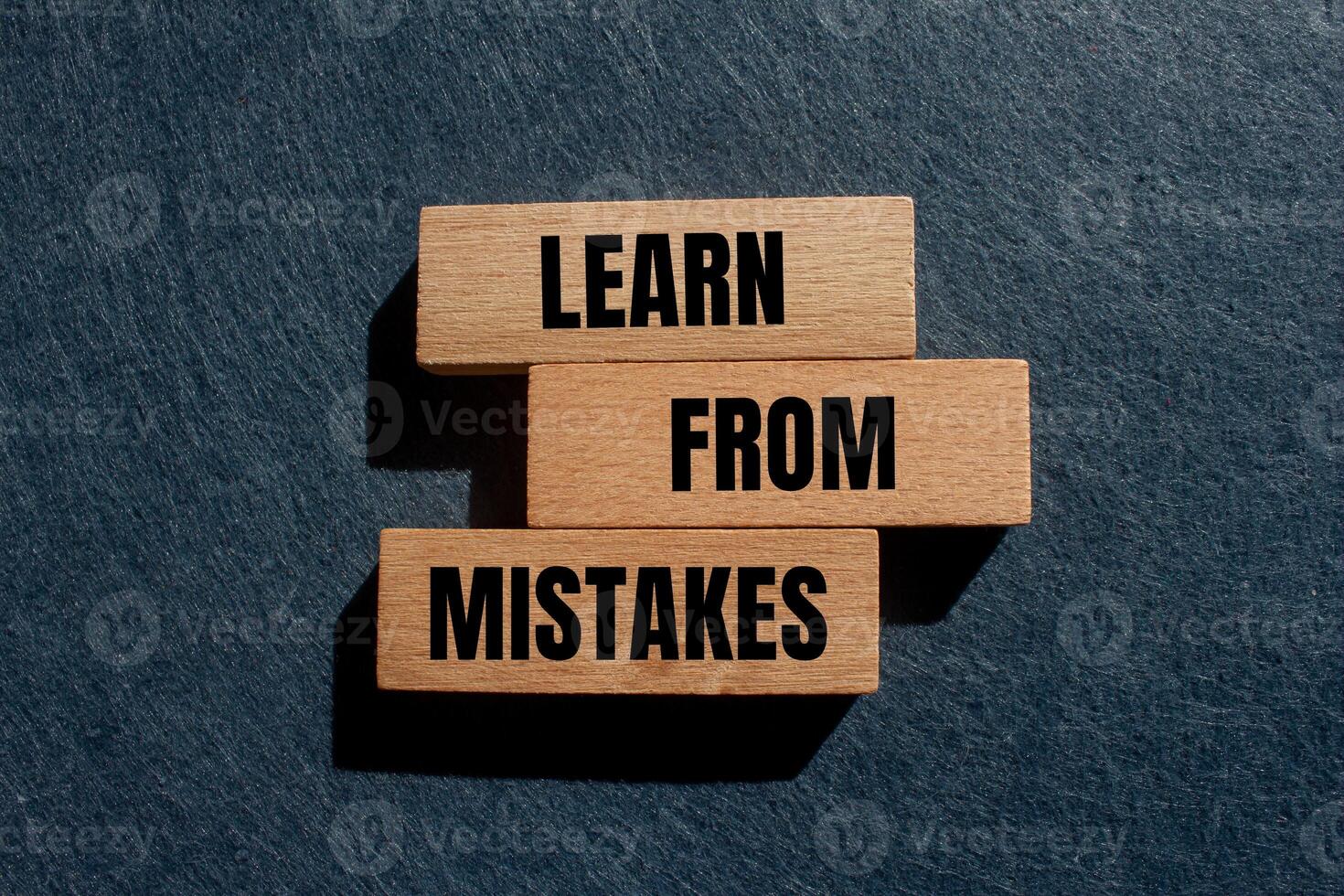 Learn from mistakes message written on wooden blocks with gray background. Conceptual learn from mistakes symbol. Copy space. photo
