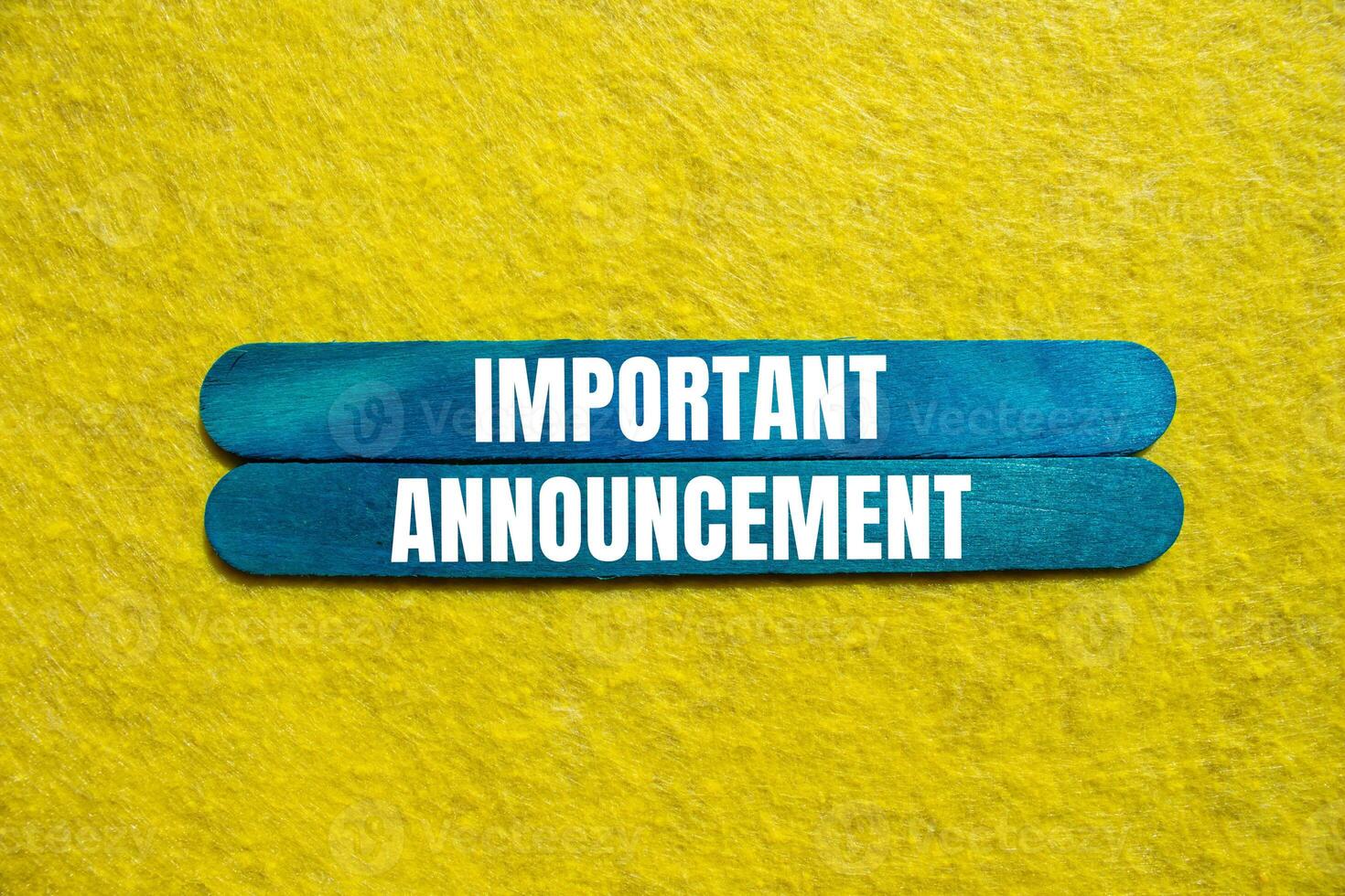 Important announcement message written on blue wooden sticks with yellow background. Conceptual important announcement symbol. Copy space. photo