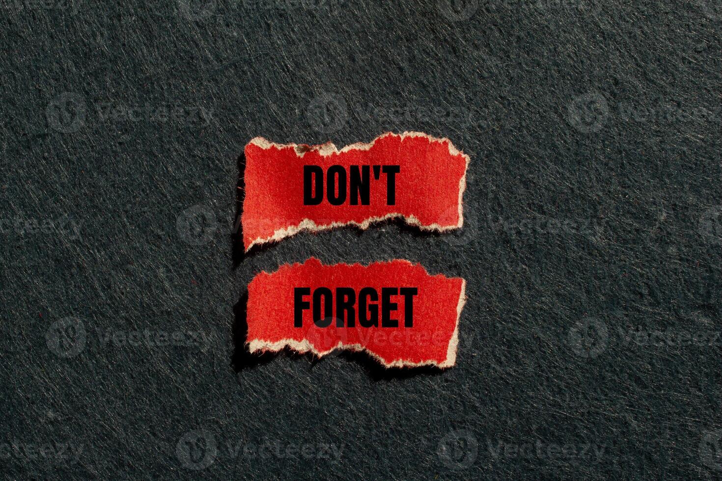 Don't forget message written on ripped torn red paper pieces with gray background. Conceptual don't forget symbol. Copy space. photo