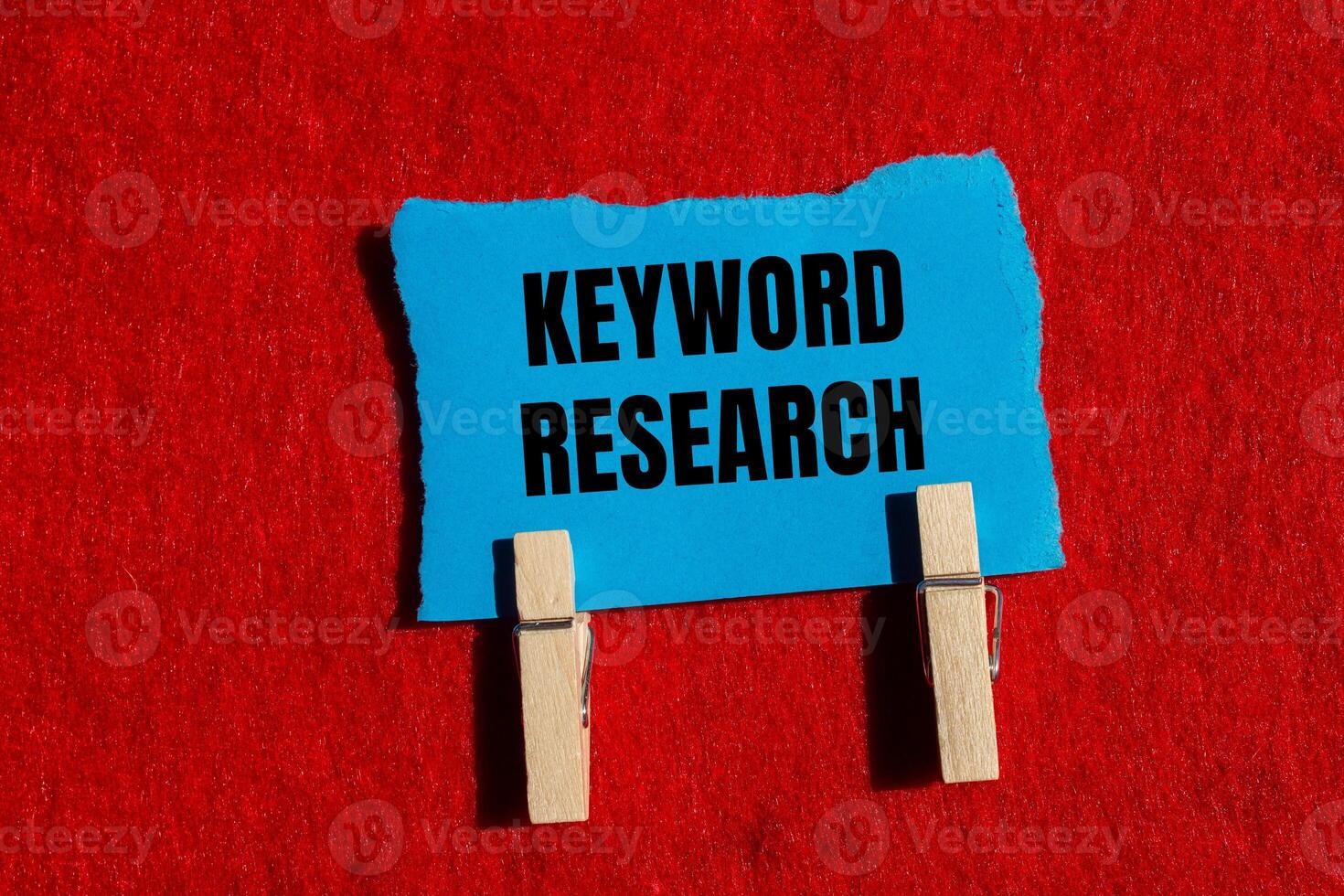 Keyword research message written on ripped torn blue paper piece with red background. Conceptual keyword research symbol. Copy space. photo