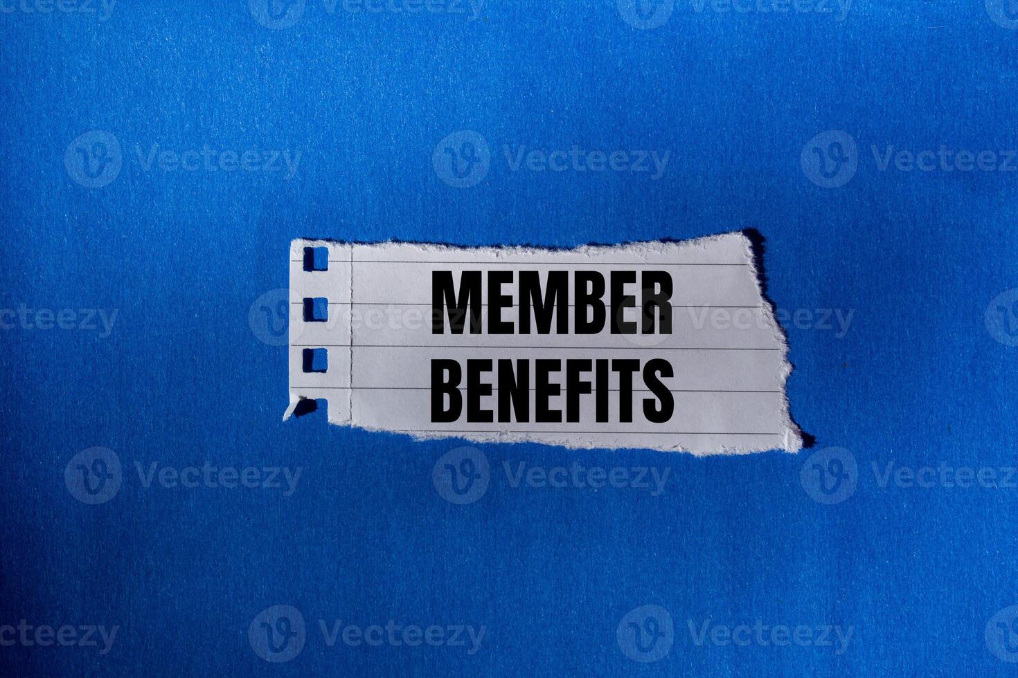 Member benefits message written on ripped torn paper piece with blue background. Conceptual member benefits symbol. Copy space. photo
