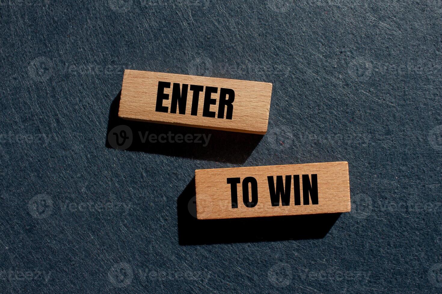 Enter to win message written on wooden blocks with gray background. Conceptual enter to win symbol. Copy space. photo