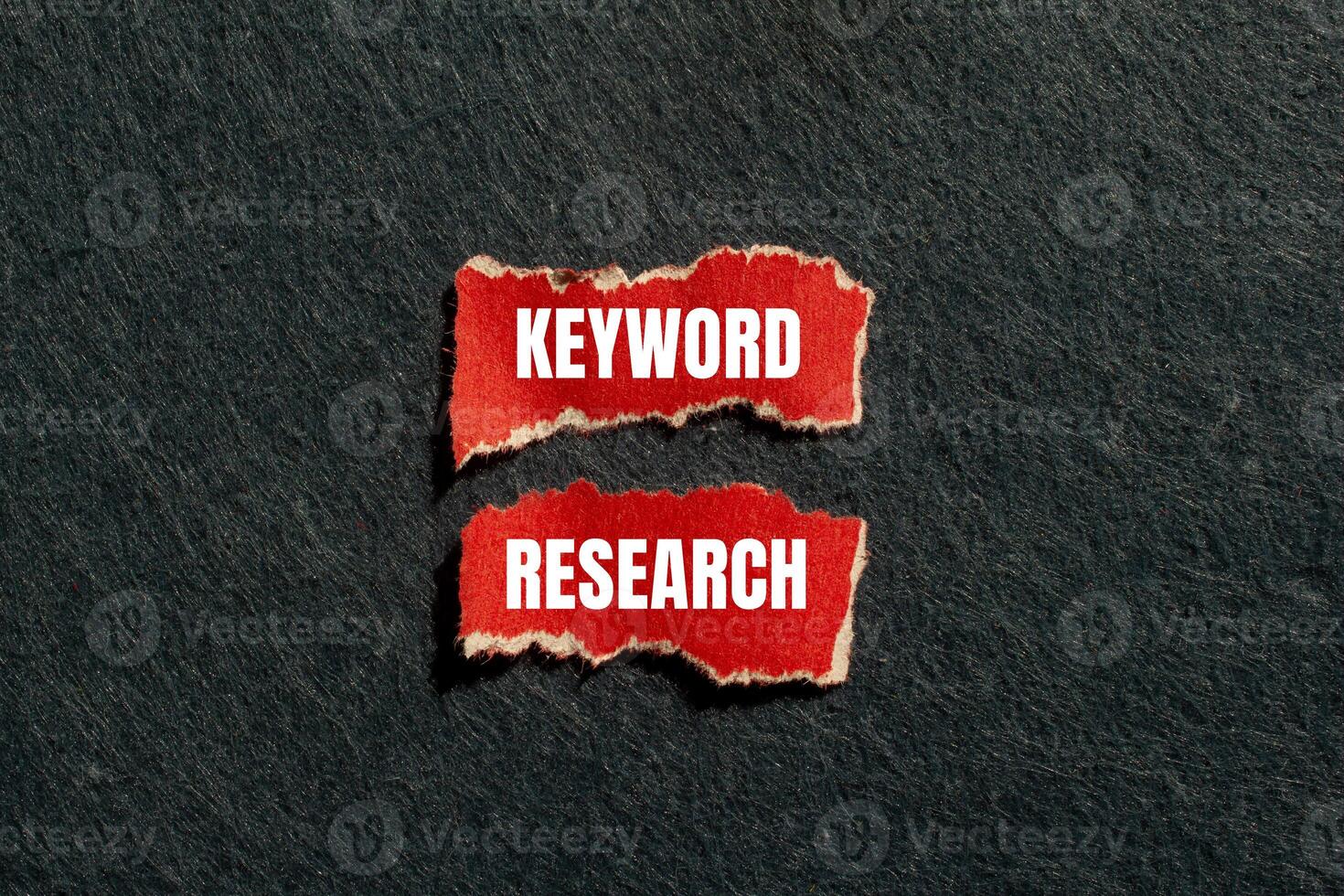 Keyword research message written on ripped torn red paper pieces with gray background. Conceptual keyword research symbol. Copy space. photo