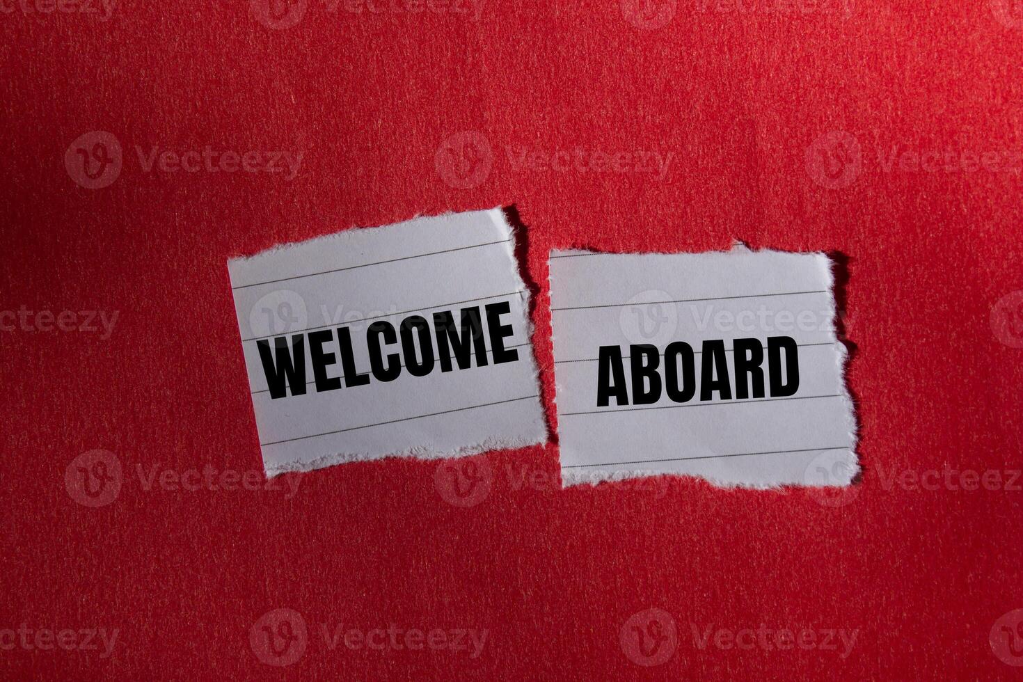 Welcome aboard message written on ripped torn paper piece with red background. Conceptual welcome aboard symbol. Copy space. photo