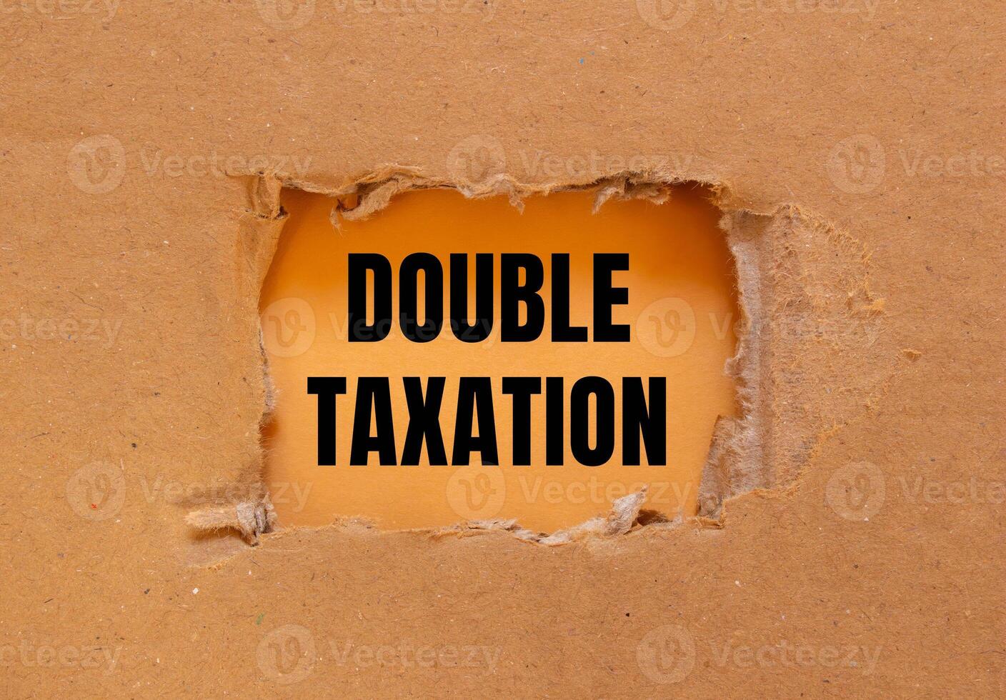 Double taxation message written on ripped torn cardboard paper with orange background. Conceptual double taxation symbol. Copy space. photo