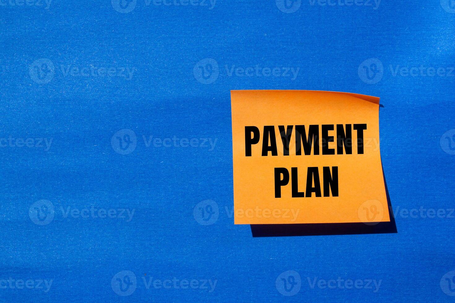 Payment plan message written on orange paper with blue background. Conceptual payment plan symbol. Copy space. photo