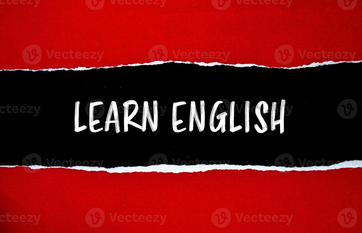 Learn english message written on ripped torn red paper with black background. Conceptual learn english symbol. Copy space. photo