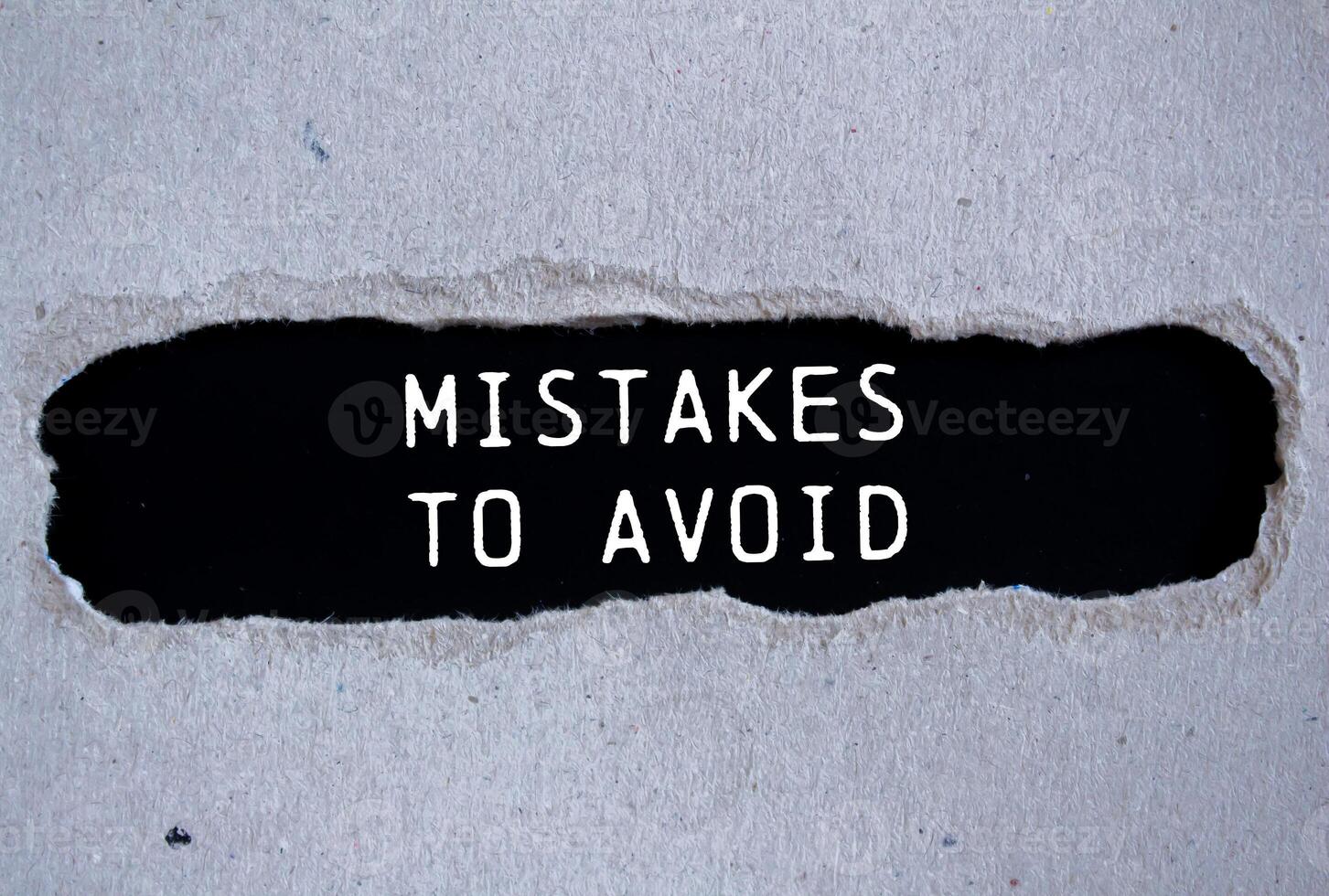 Mistakes to avoid message written on ripped torn gray paper with black background. Conceptual mistakes to avoid symbol. Copy space. photo
