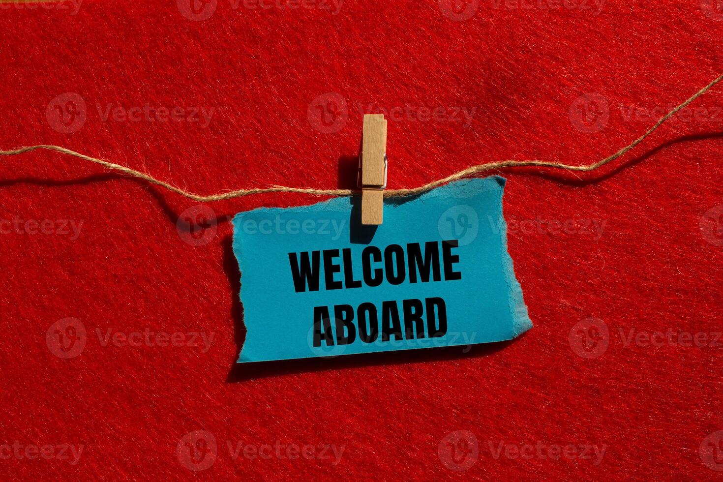 Welcome aboard message written on ripped torn blue paper piece with red background. Conceptual welcome aboard symbol. Copy space. photo