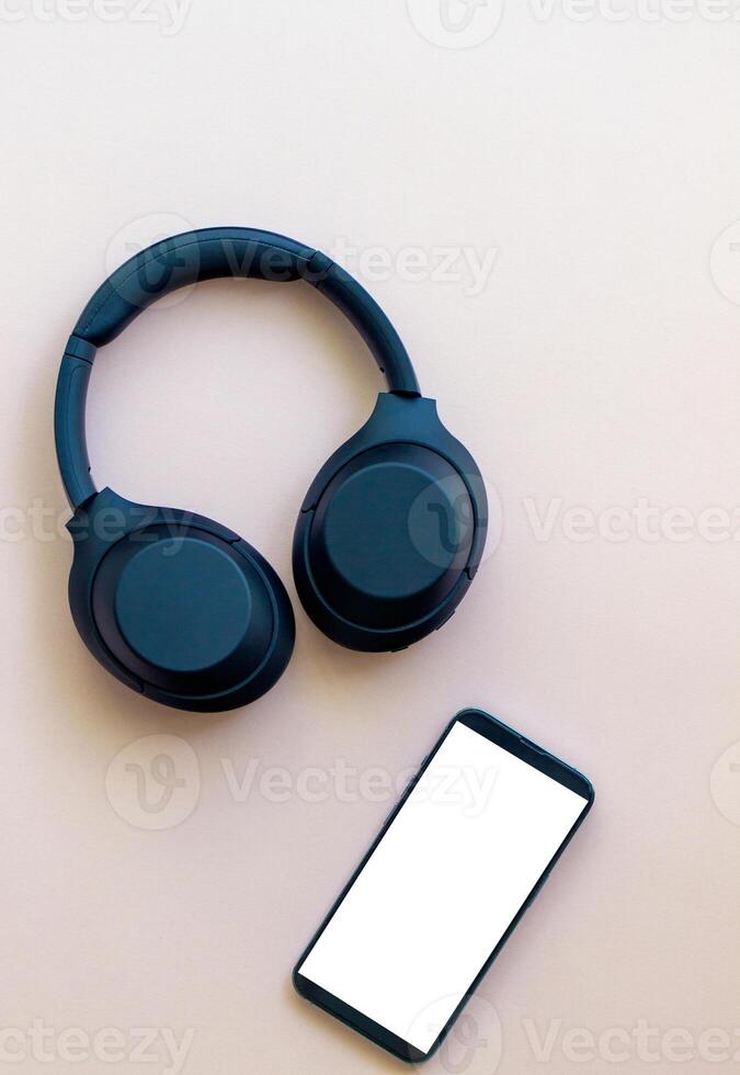 wireless headphones and smartphone on a plain pink background. music and entertainment, phone screen photo