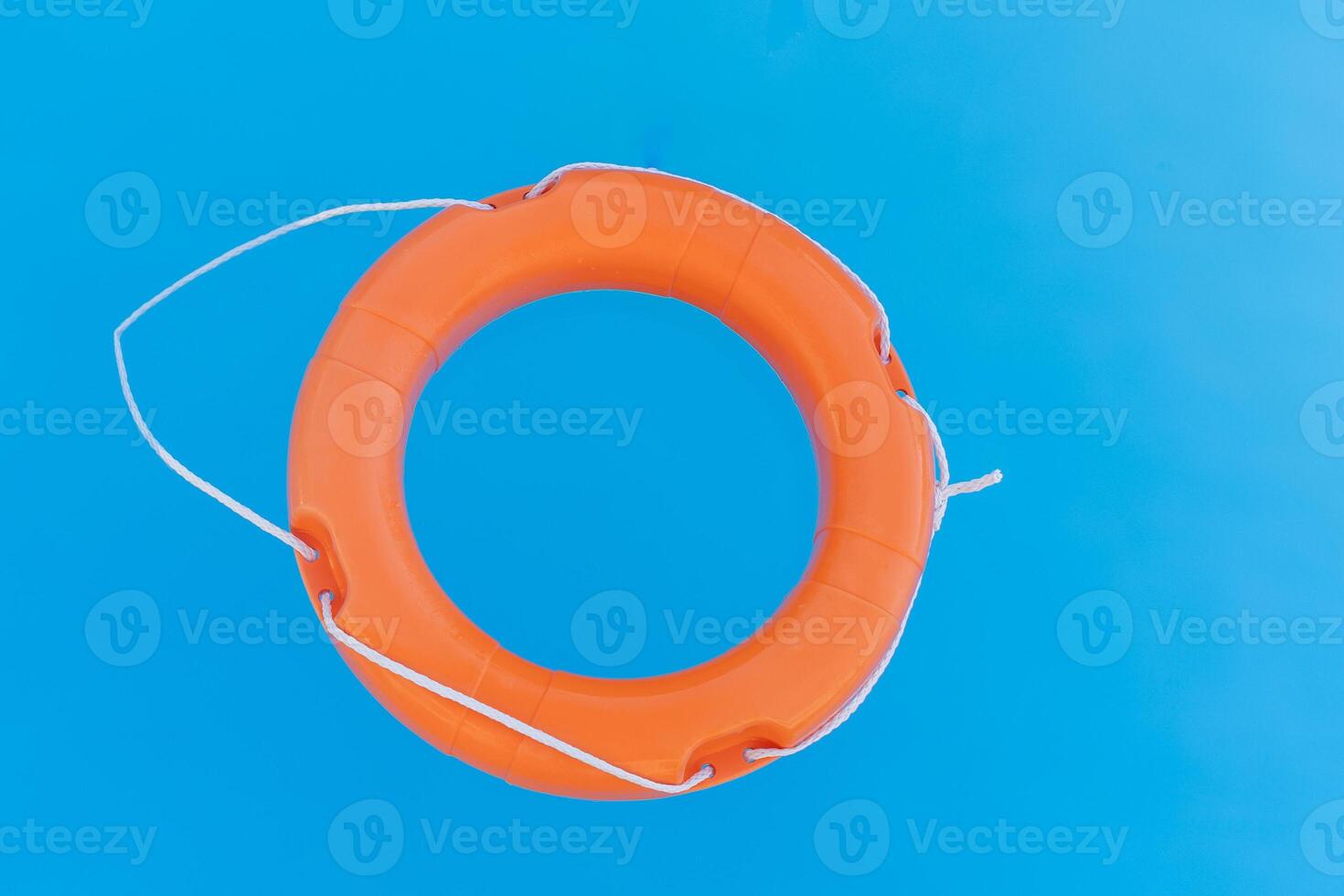 bright orange lifebuoy floating on the surface of the water, rescuing people on the water photo