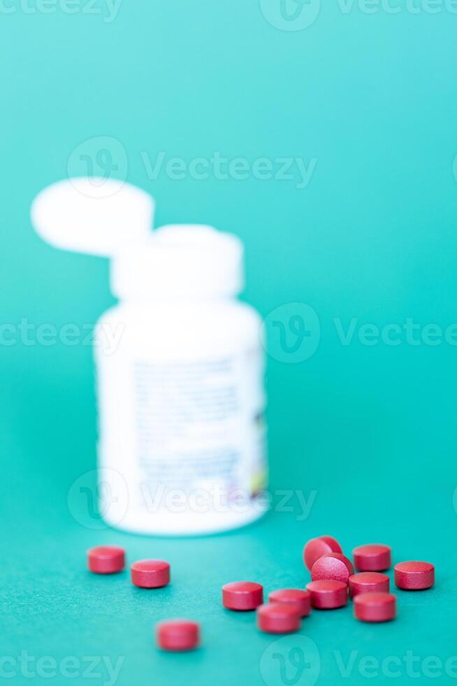 jar of pills and a handful of red round pills on a dark green background, sedative, anti-stress, medical concept photo