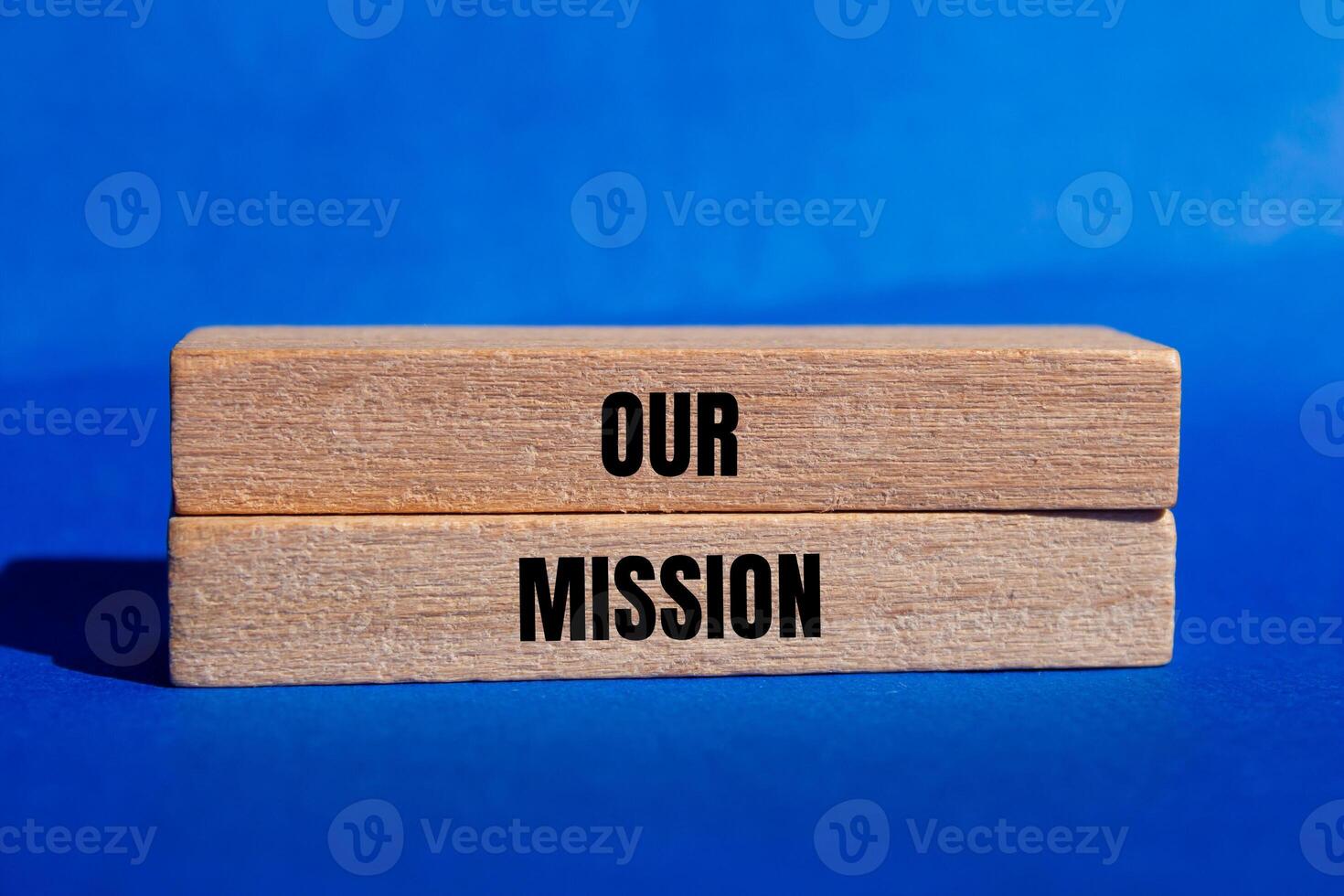 Our mission message written on wooden blocks with blue background. Conceptual our mission symbol. Copy space. photo
