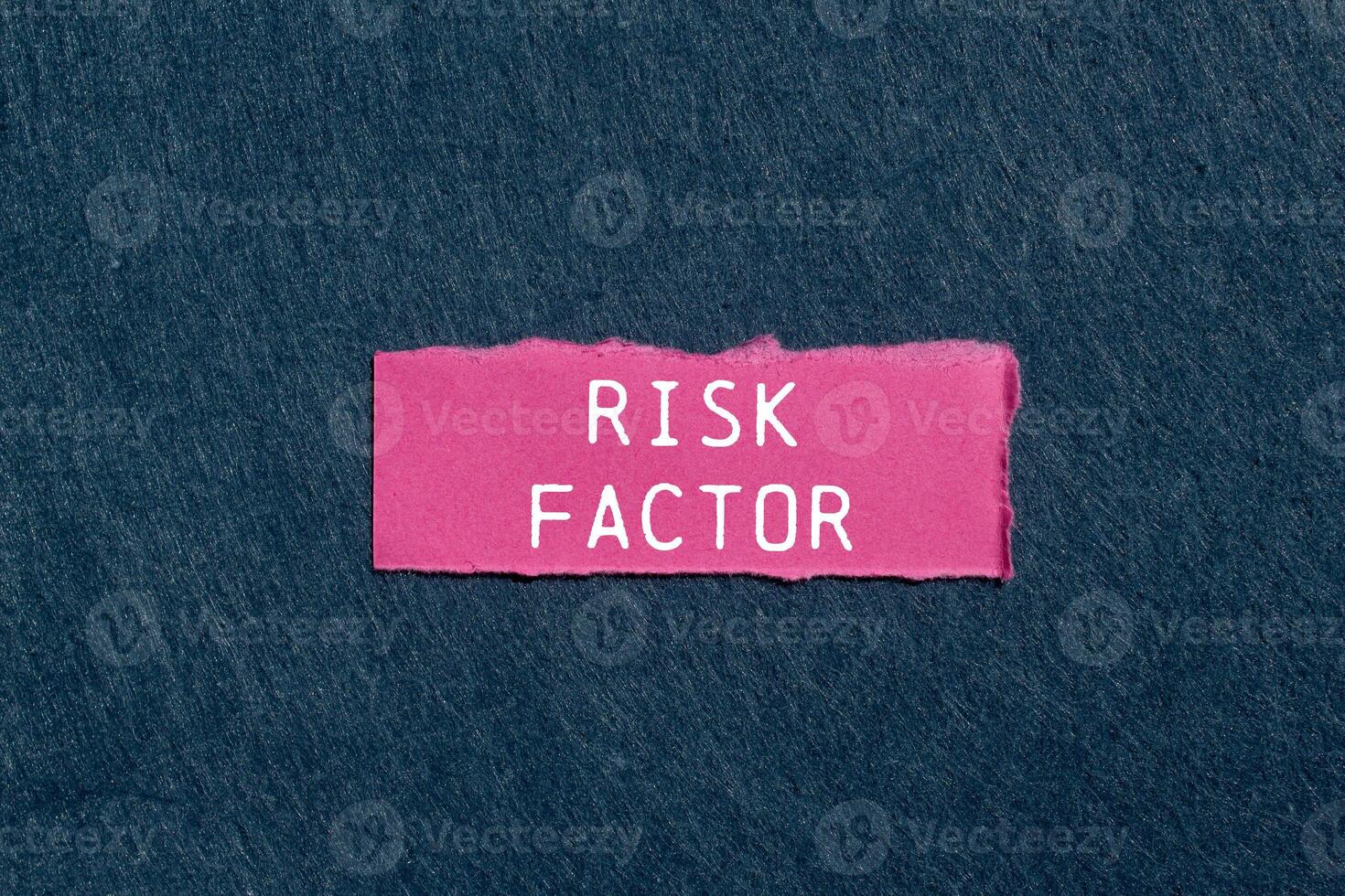 Risk factor message written on ripped pink torn paper piece on gray background. Conceptual risk factor symbol. Copy space. photo