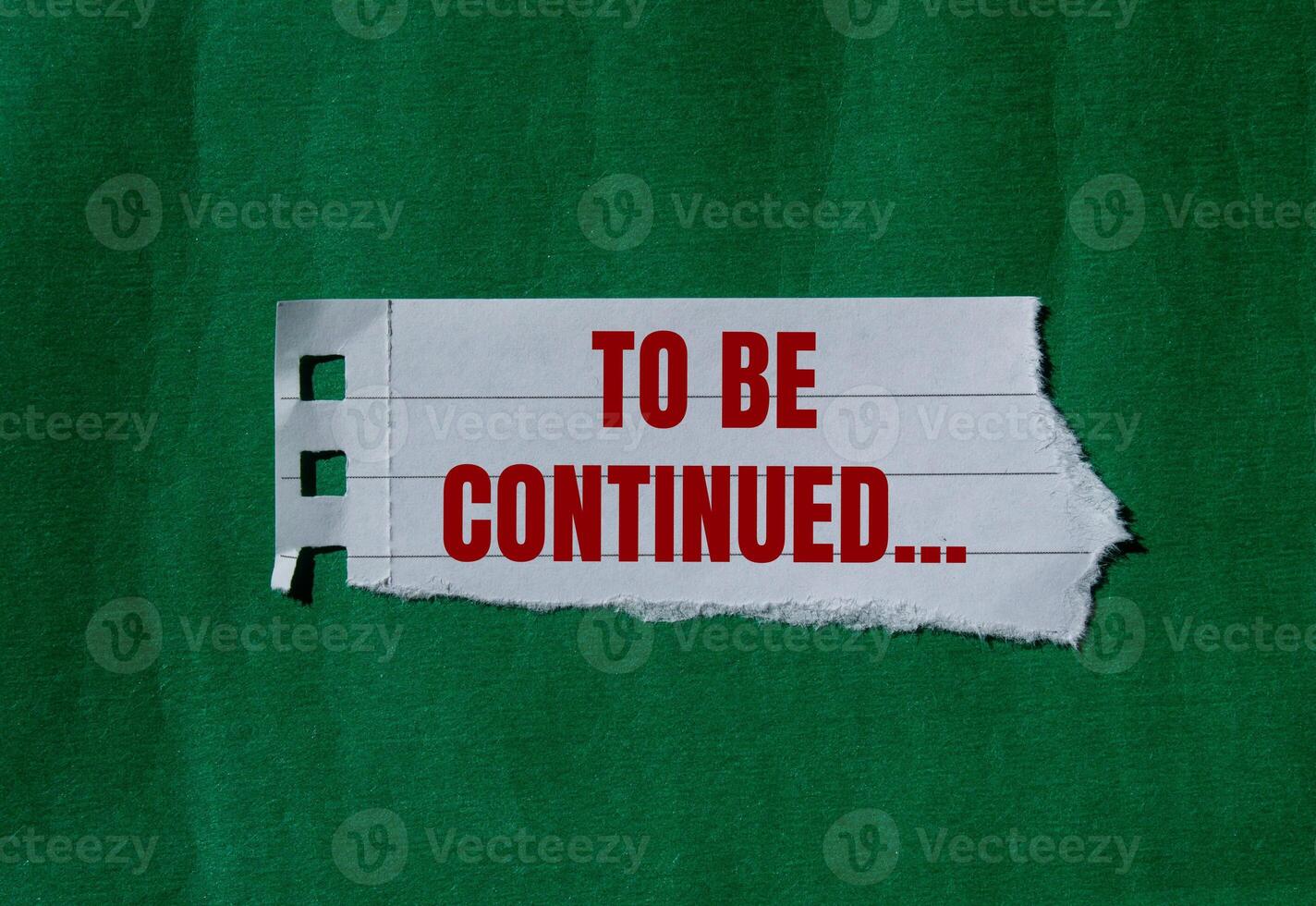 To be continued message written on ripped torn paper with green background. Conceptual to be continued symbol. Copy space. photo