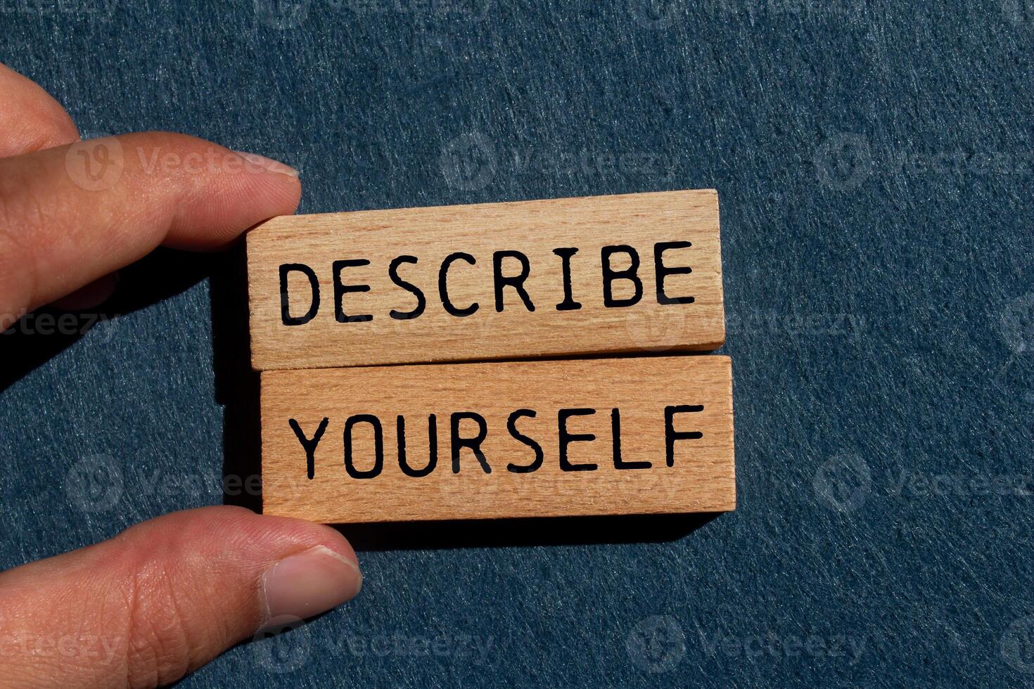 Describe yourself message written on wooden blocks on gray felt background. Conceptual describe yourself symbol. Copy space. photo