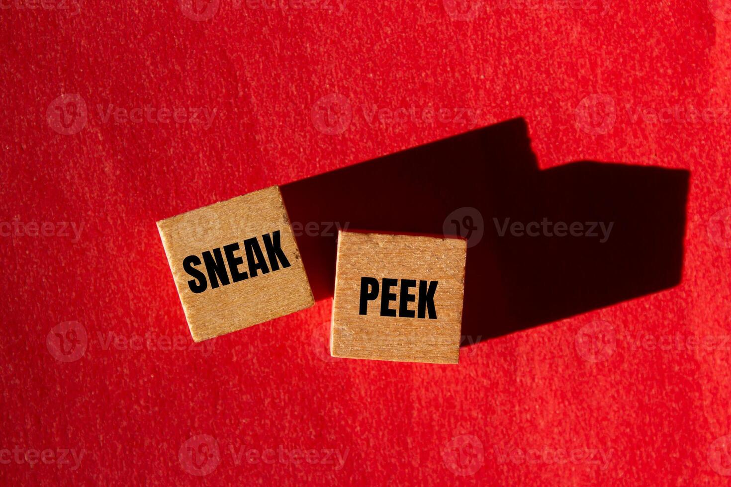 Sneak peek message written on wooden cubes with red background. Conceptual sneak peek symbol. Copy space. photo
