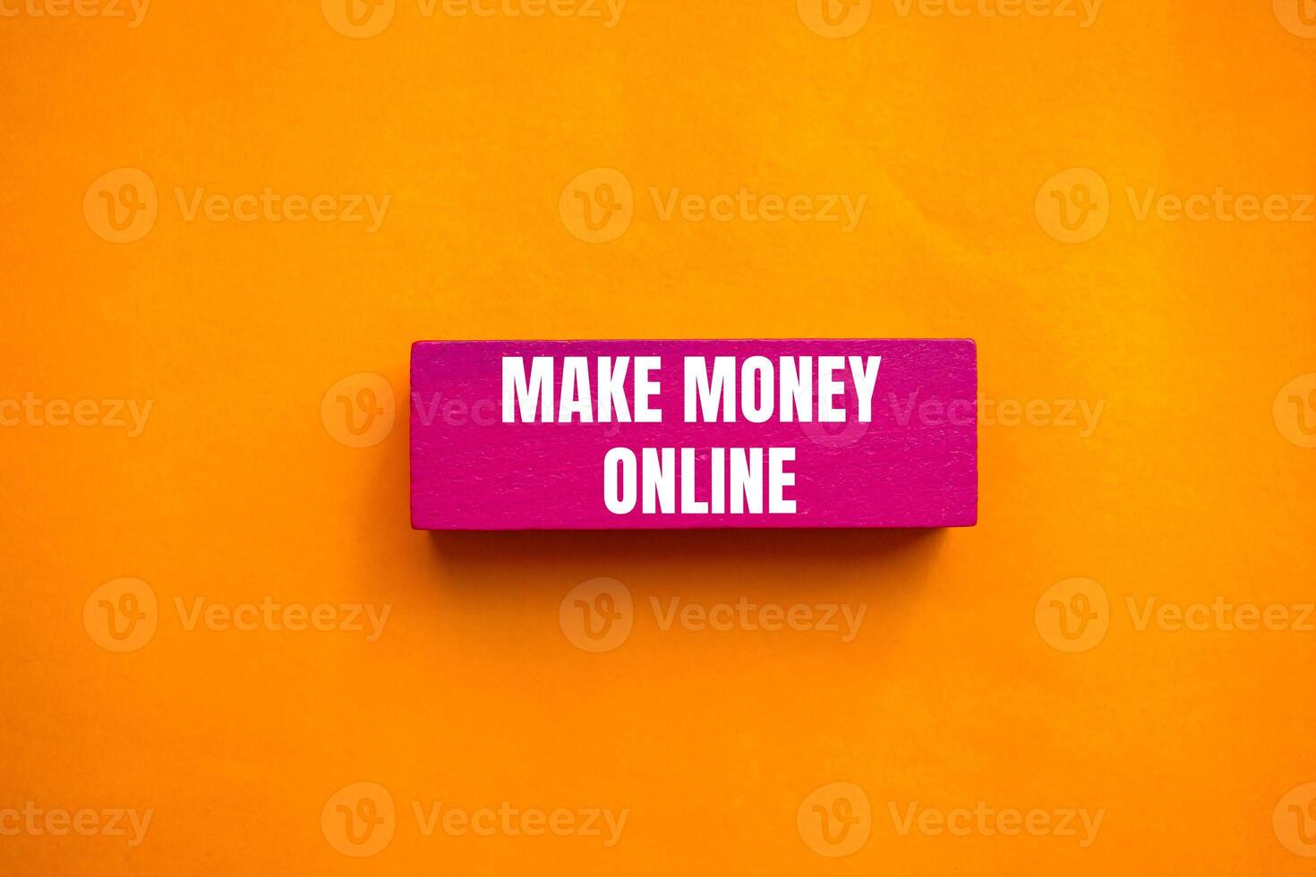 Make money online message written on pink wooden block with orange background. Conceptual make money online symbol. Copy space. photo