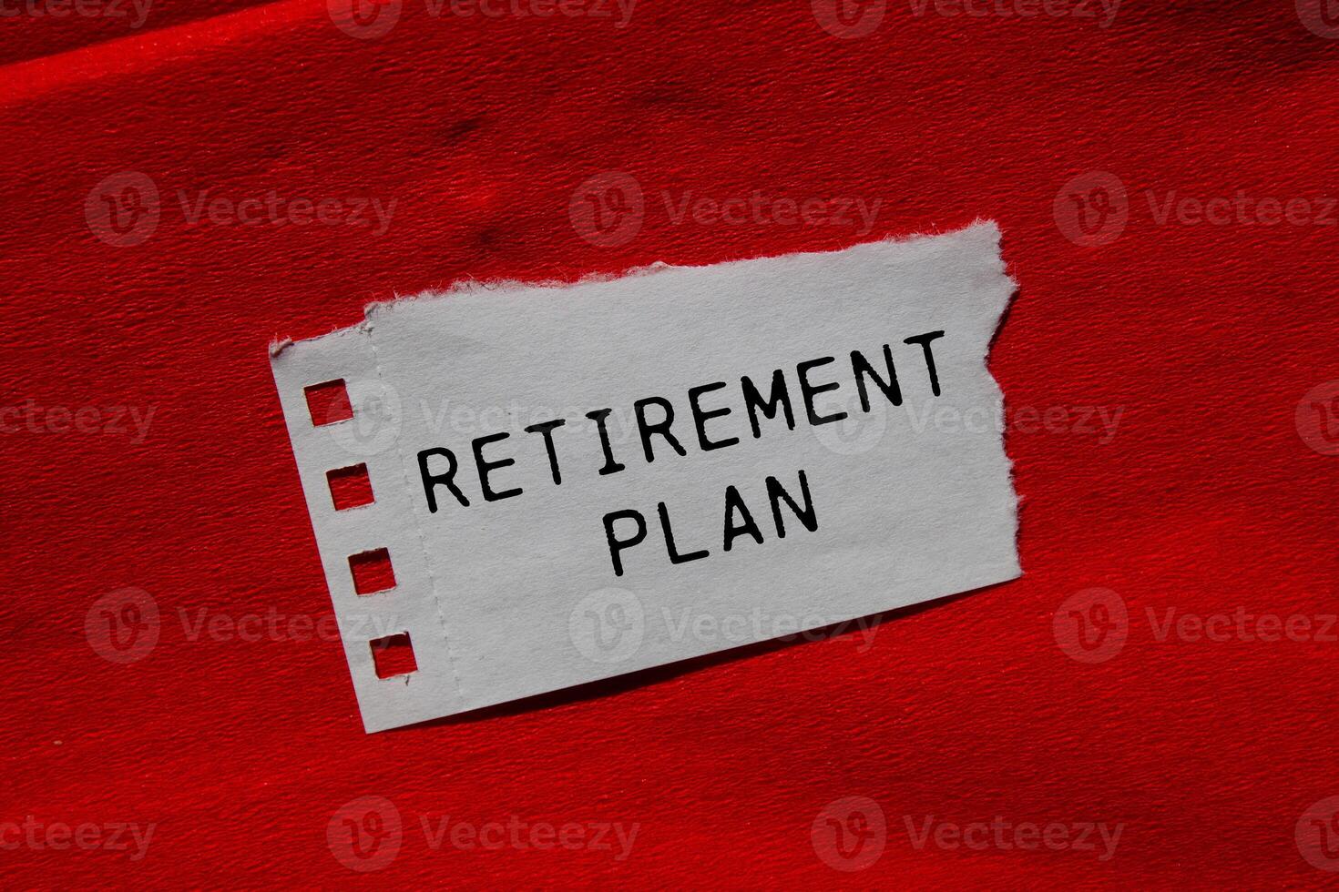 Retirement plan message written on ripped torn paper piece on red background. Conceptual retirement plan symbol. Copy space. photo