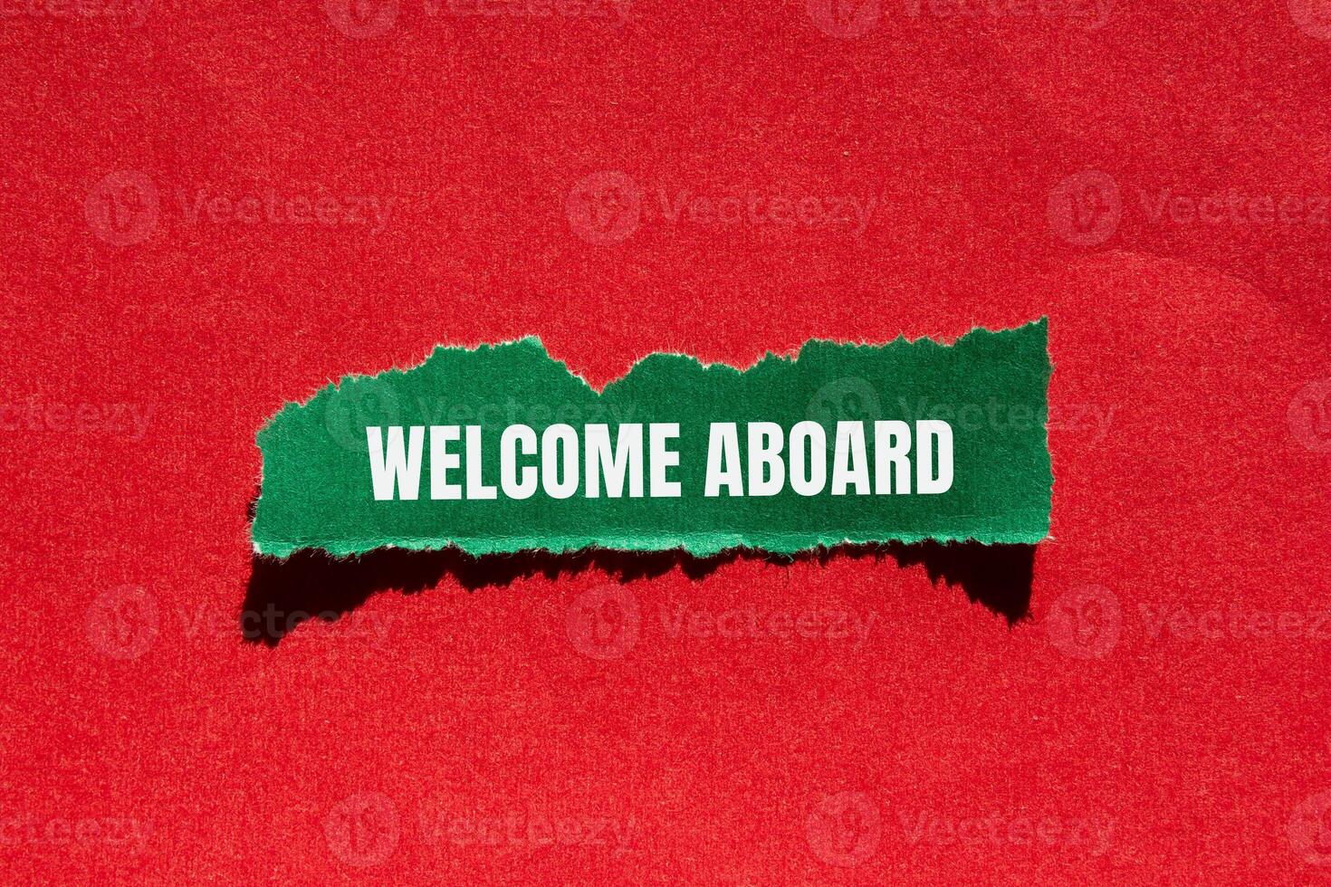 Welcome aboard message written on ripped torn green paper piece with red background. Conceptual welcome aboard symbol. Copy space. photo