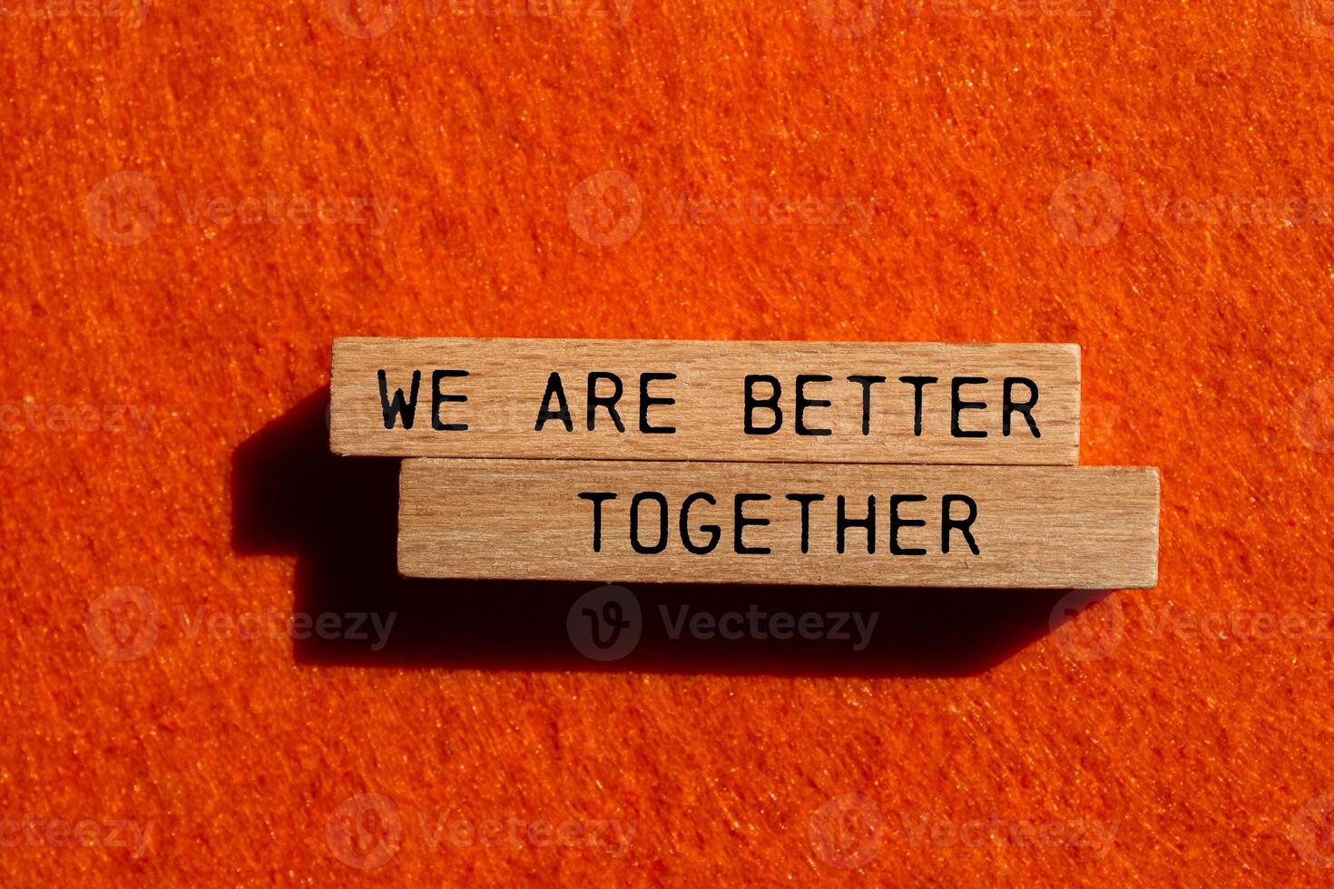 We are better together message written on wooden blocks on orange felt background. Conceptual we are better together symbol. Copy space. photo