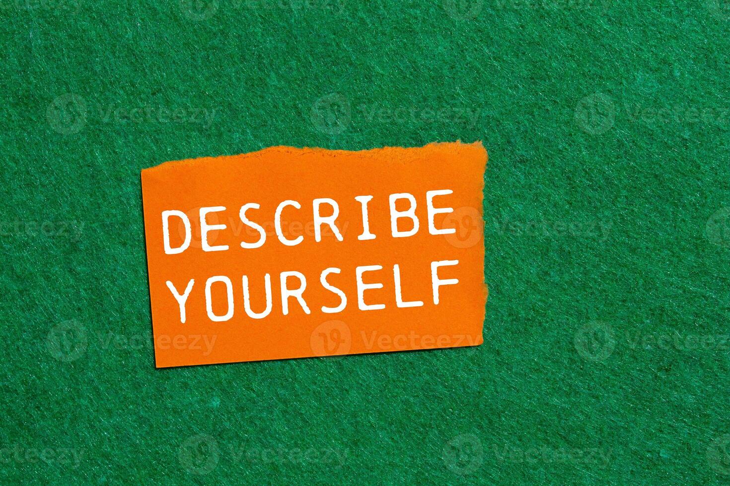 Describe yourself message written on ripped orange torn paper piece on green background. Conceptual describe yourself symbol. Copy space. photo