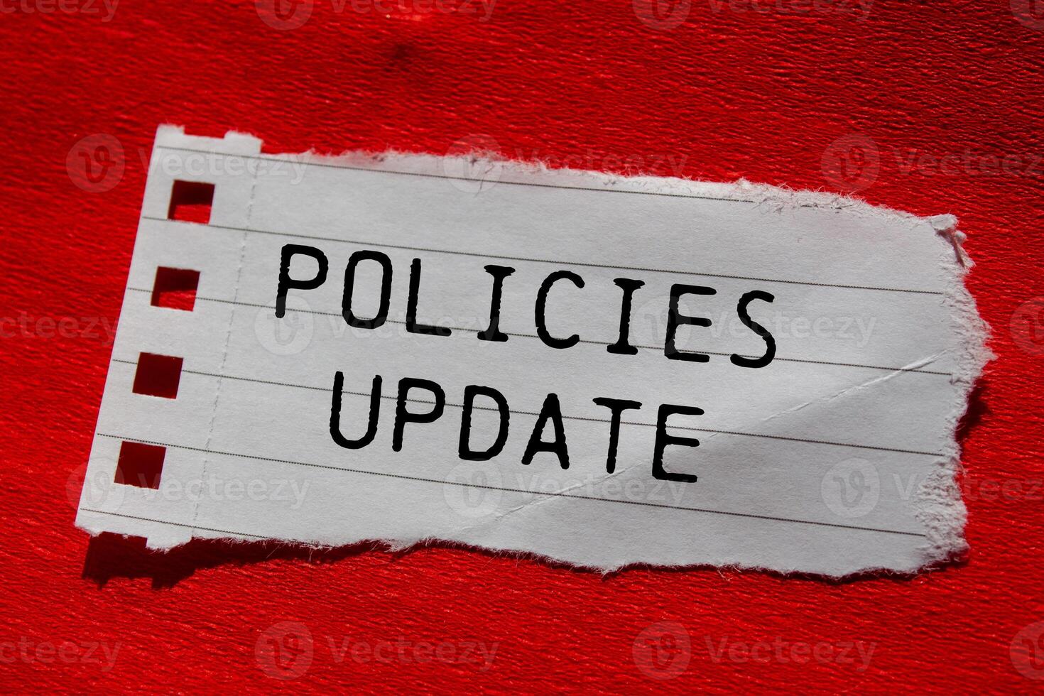 Policies update message written on ripped torn paper piece with red background. Conceptual policies update symbol. Copy space. photo
