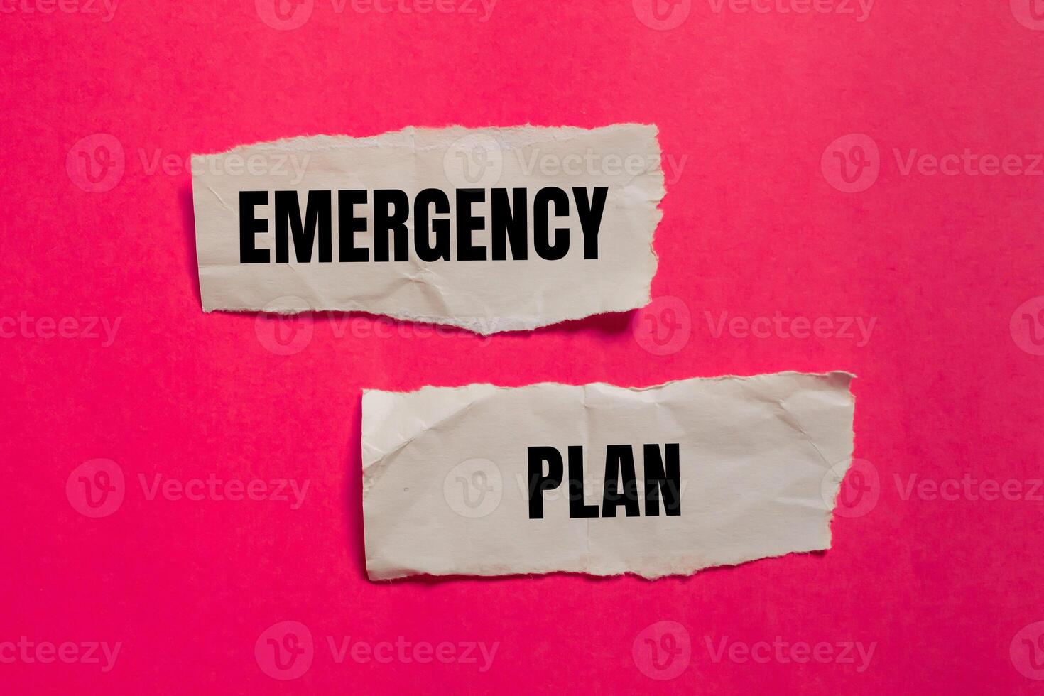 Emergency plan message written on ripped paper pieces with pink background. Conceptual emergency plan symbol. Copy space. photo