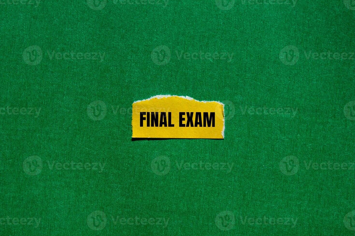 Final exam message written on ripped torn yellow paper piece with green background. Conceptual final exam symbol. Copy space. photo