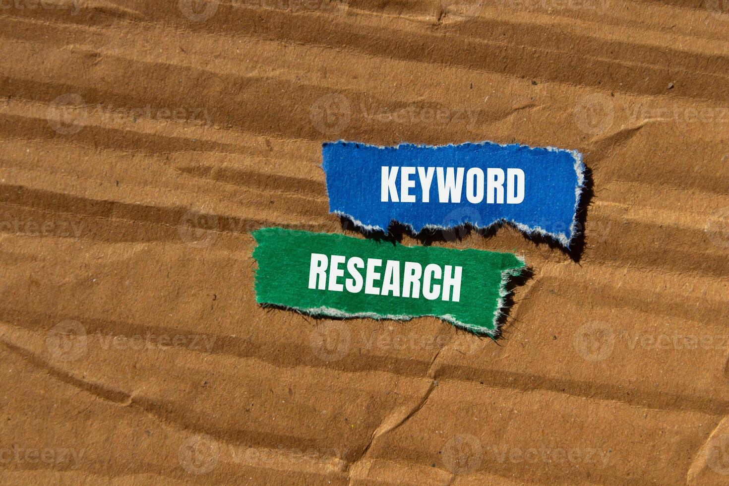 Keyword research words written on ripped torn paper pieces with cardboard background. Conceptual keyword research symbol. Copy space. photo