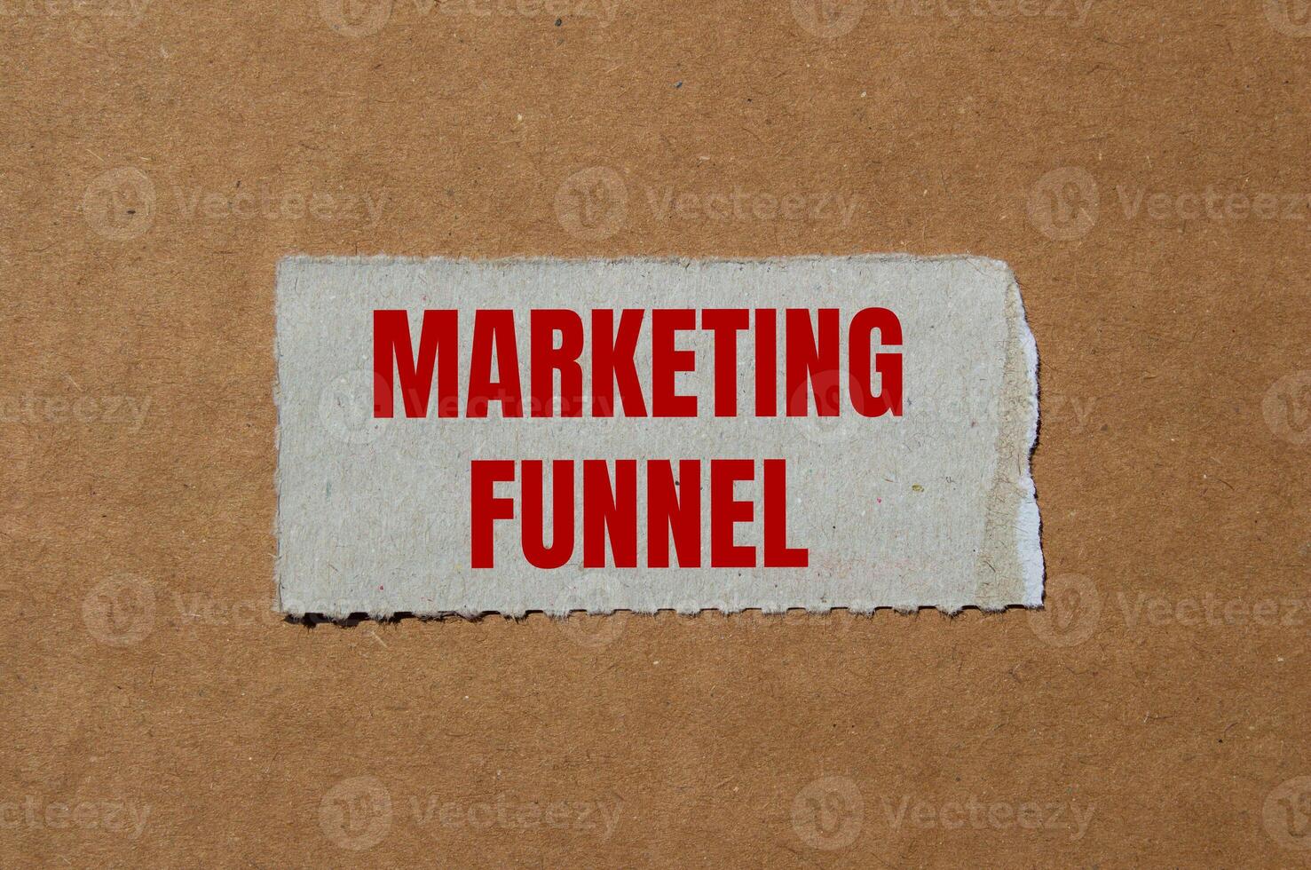 Marketing funnel message written on ripped torn paper piece with cardboard background. Conceptual marketing funnel symbol. Copy space. photo