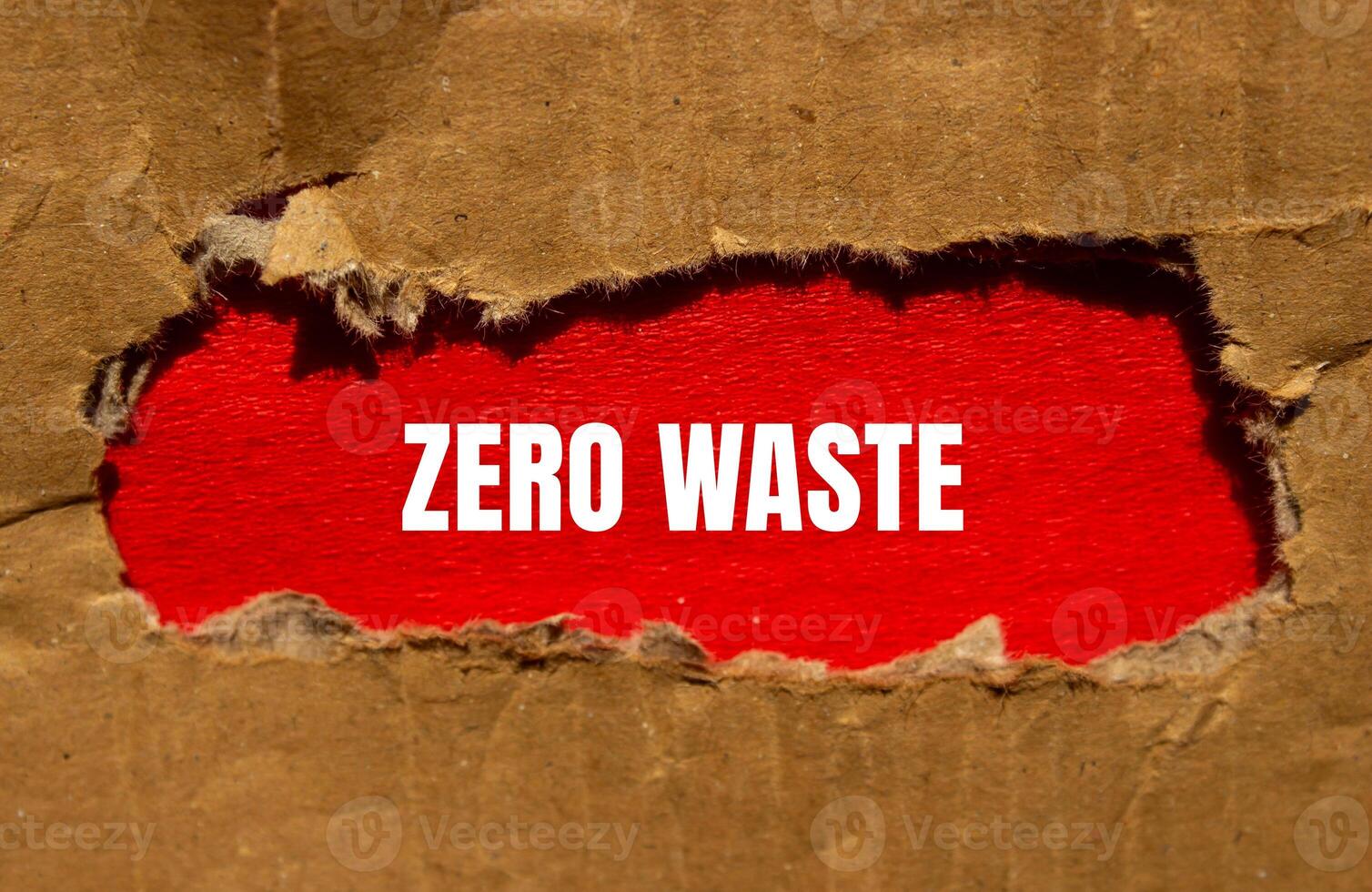 Zero waste message written on torn cardboard paper with red background. Conceptual zero waste symbol. Copy space. photo
