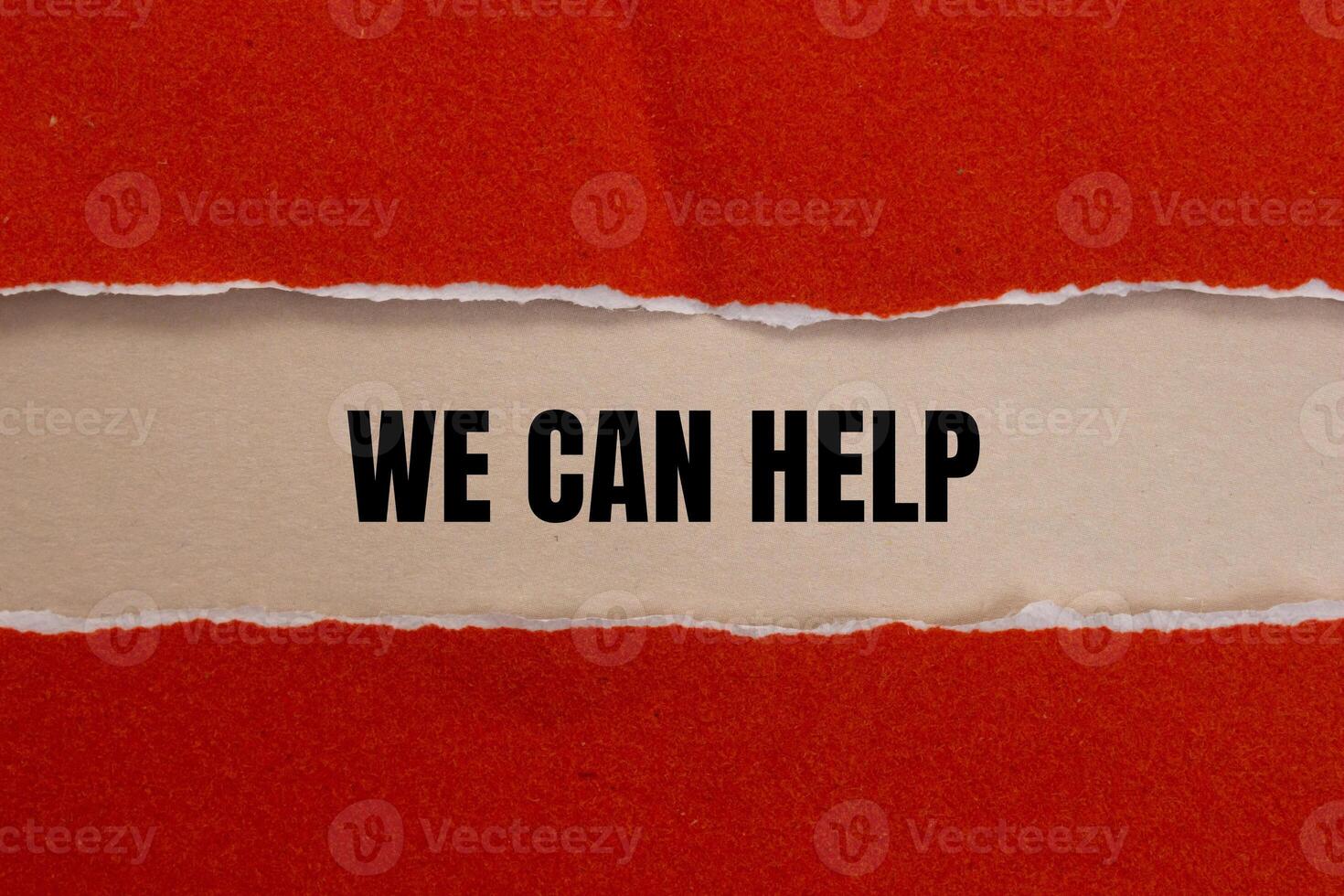 We can help message written on ripped red torn paper with beige background. Conceptual we can help symbol. Copy space. photo