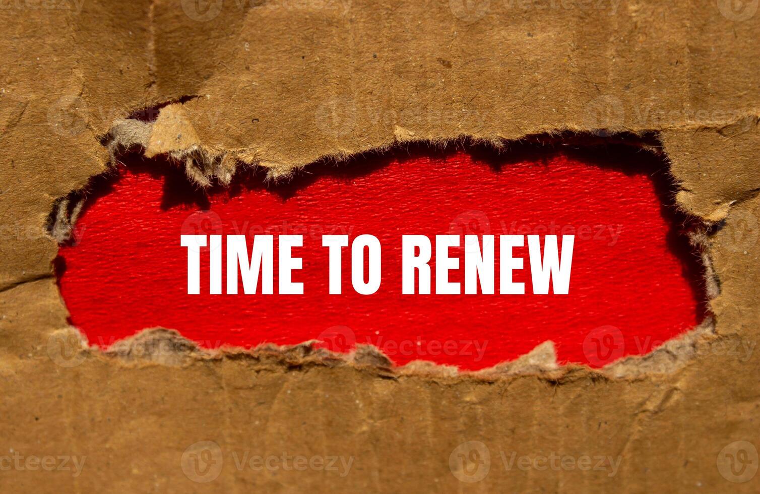 Time to renew message written on torn cardboard paper with red background. Conceptual time to renew symbol. Copy space. photo
