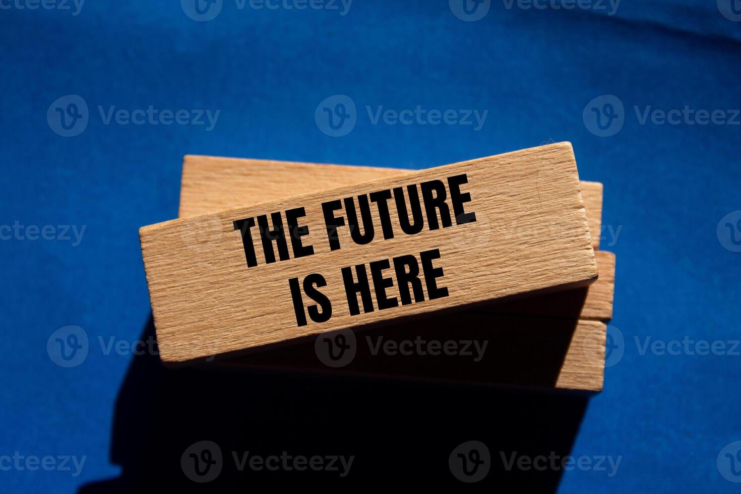 The future is here message written on wooden blocks on blue background. Conceptual the future is here symbol. Copy space. photo