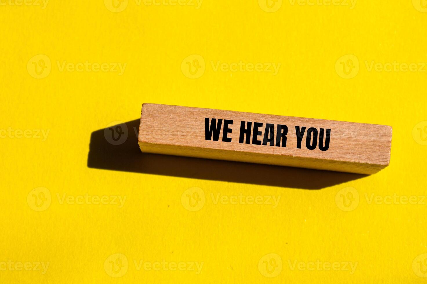 We hear you message written on wooden block with yellow background. Conceptual we hear you symbol. Copy space. photo