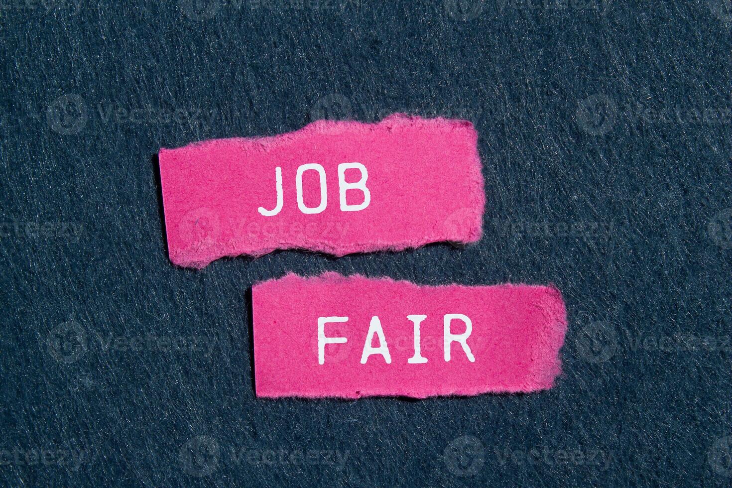 Job fair message written on ripped torn pink paper pieces on gray background. Conceptual job fair symbol. Copy space. photo