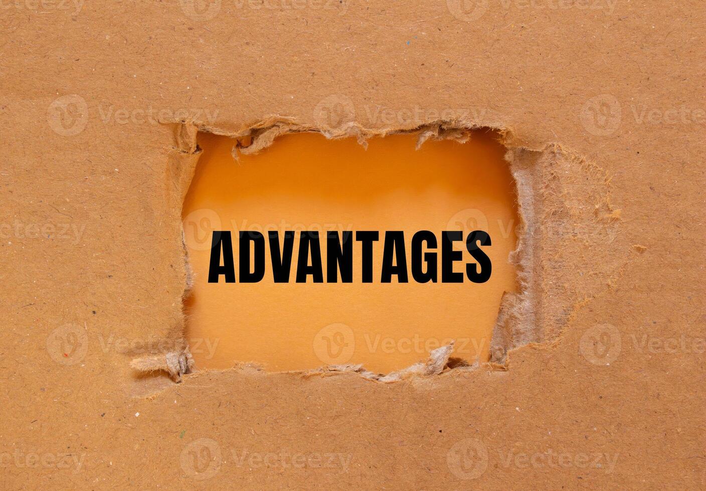 Advantages message written on ripped torn cardboard paper with orange background. Conceptual advantages symbol. Copy space. photo
