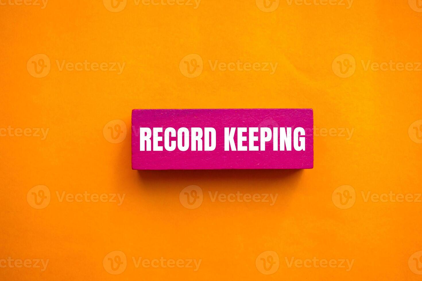 Record keeping message written on pink wooden block with orange background. Conceptual record keeping symbol. Copy space. photo