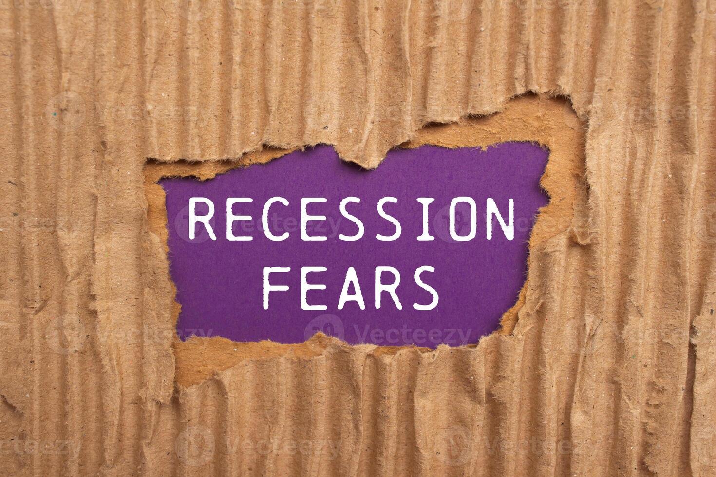Recession fears message written on ripped torn cardboard paper on purplebackground. Conceptual recession fears symbol. Copy space. photo