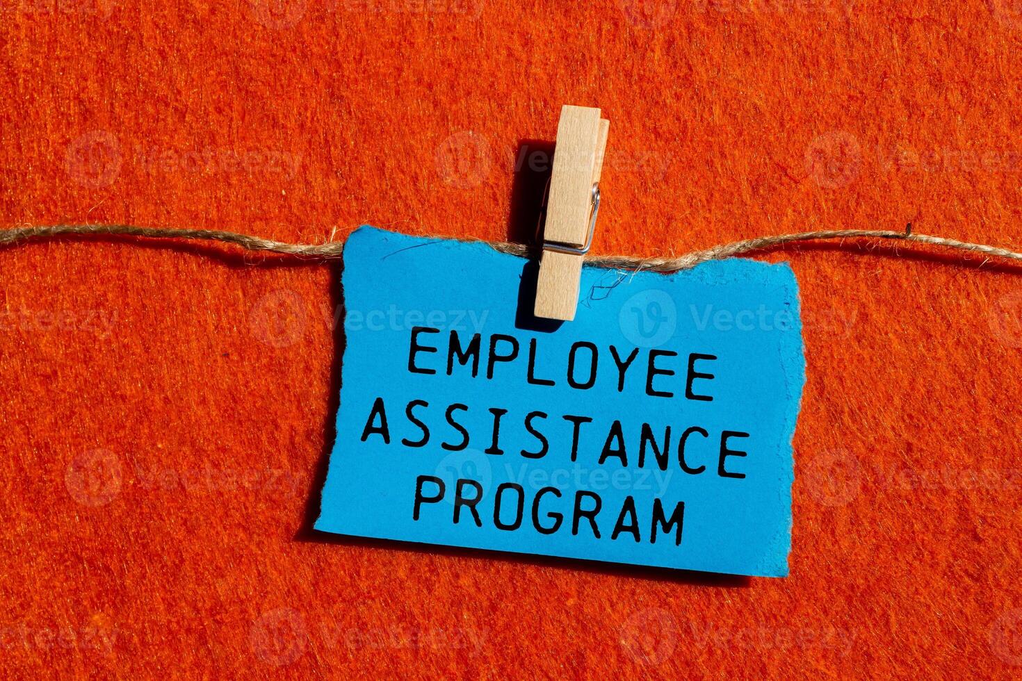 Employee assistance program message written on ripped blue torn paper piece on orange background. Conceptual employee assistance program symbol. Copy space. photo