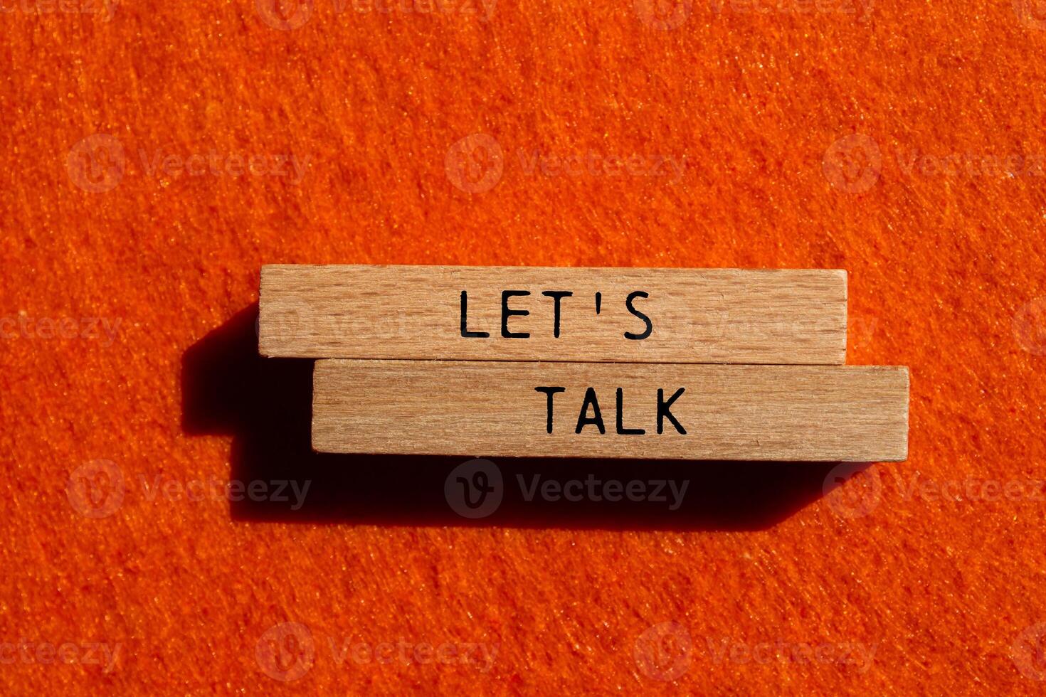 Let's talk message written on wooden blocks on orange felt background. Conceptual let's talk symbol. Copy space. photo