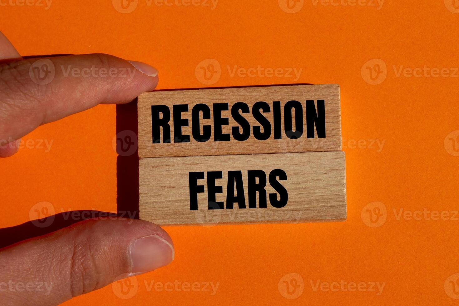 Recession fears message written on wooden blocks on orange background. Conceptual recession fears symbol. Copy space. photo