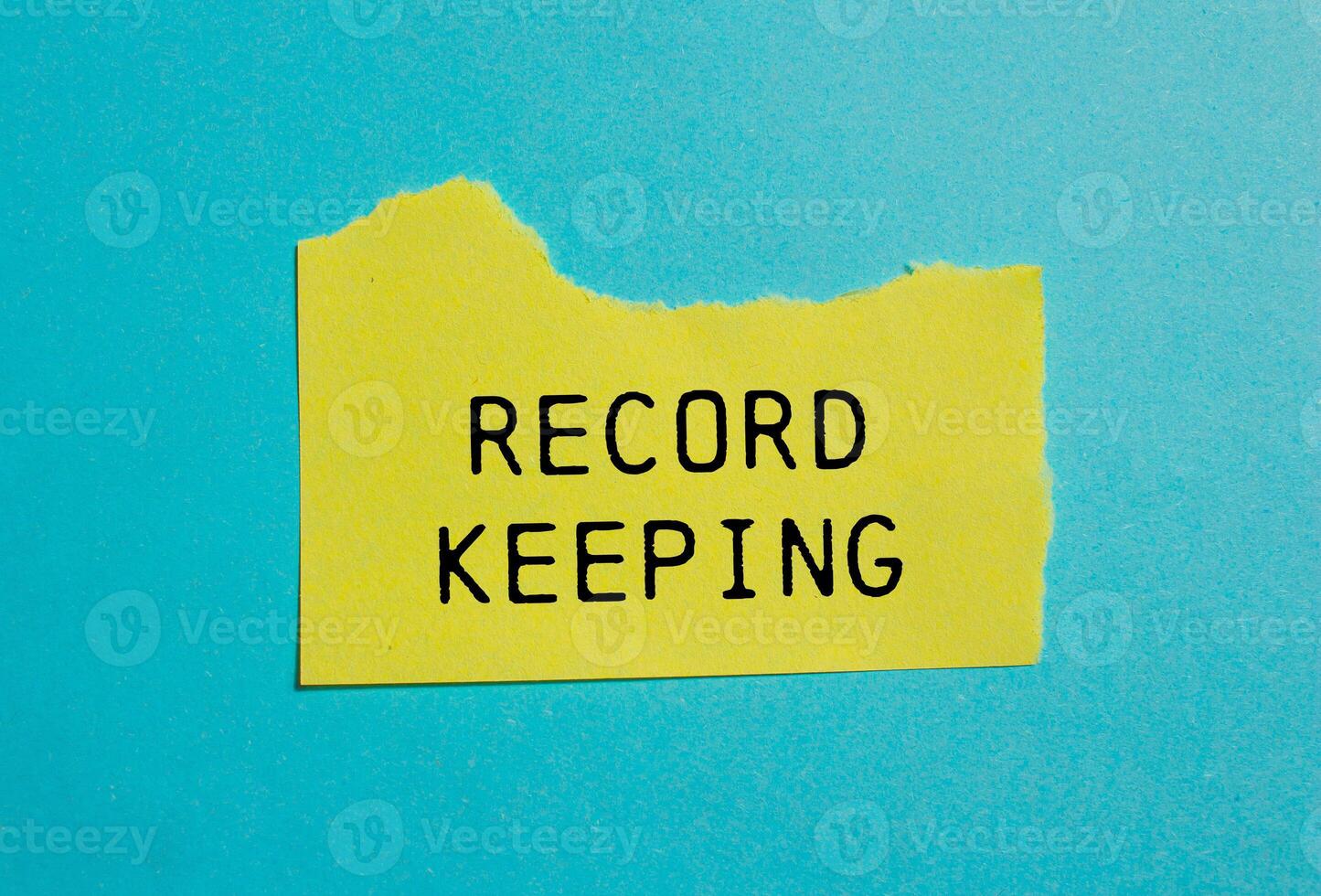 Record keeping message written on ripped torn yellow paper with blue background. Conceptual record keeping symbol. Copy space. photo