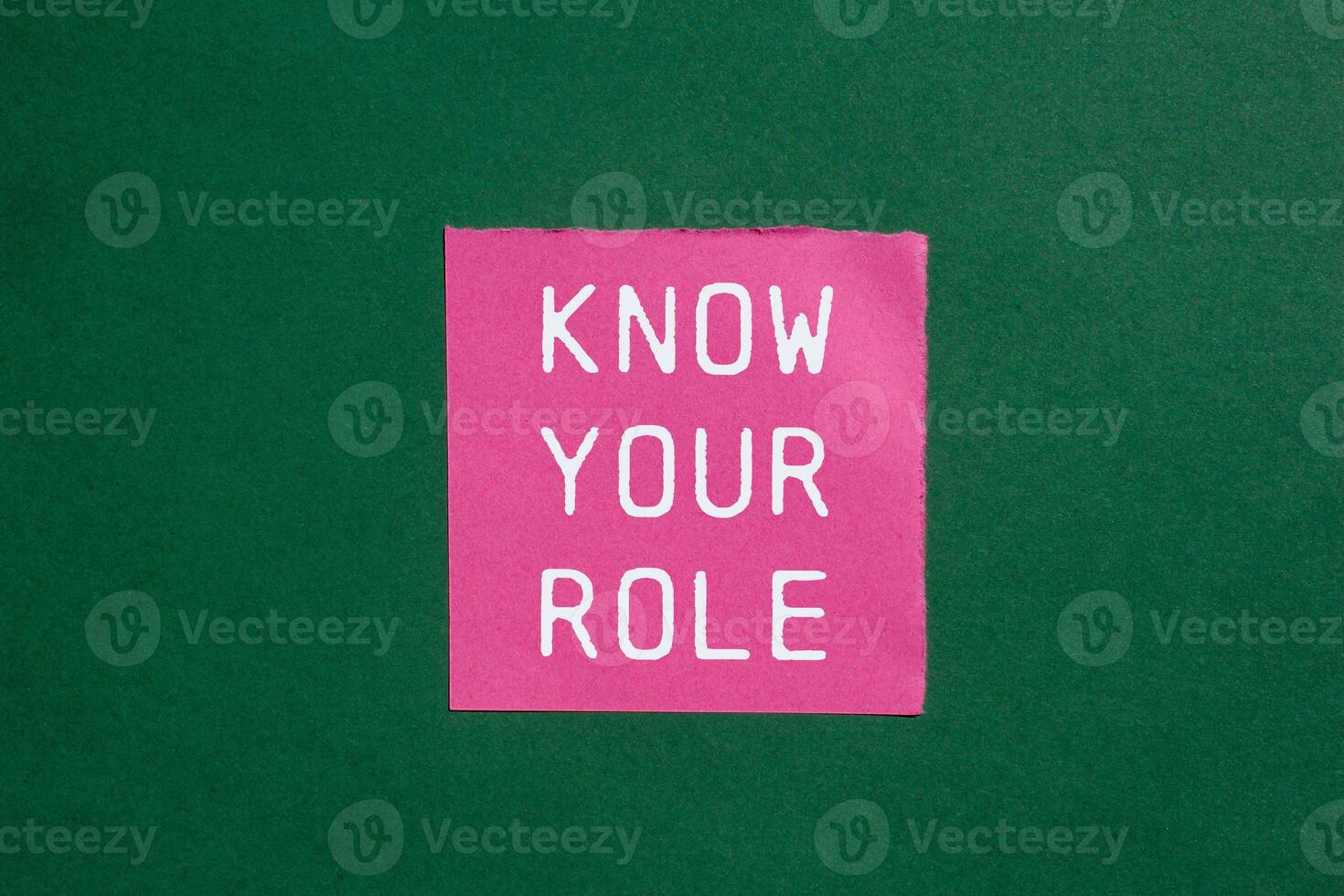 Know your role message written on ripped torn pink paper on green background. Conceptual know your role symbol. Copy space. photo