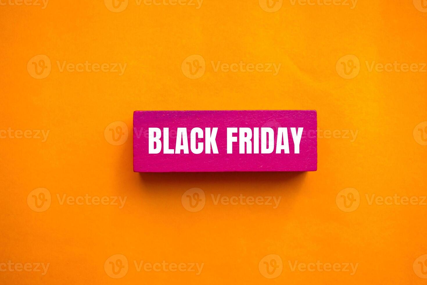 Black friday message written on pink wooden block with orange background. Conceptual black friday symbol. Copy space. photo